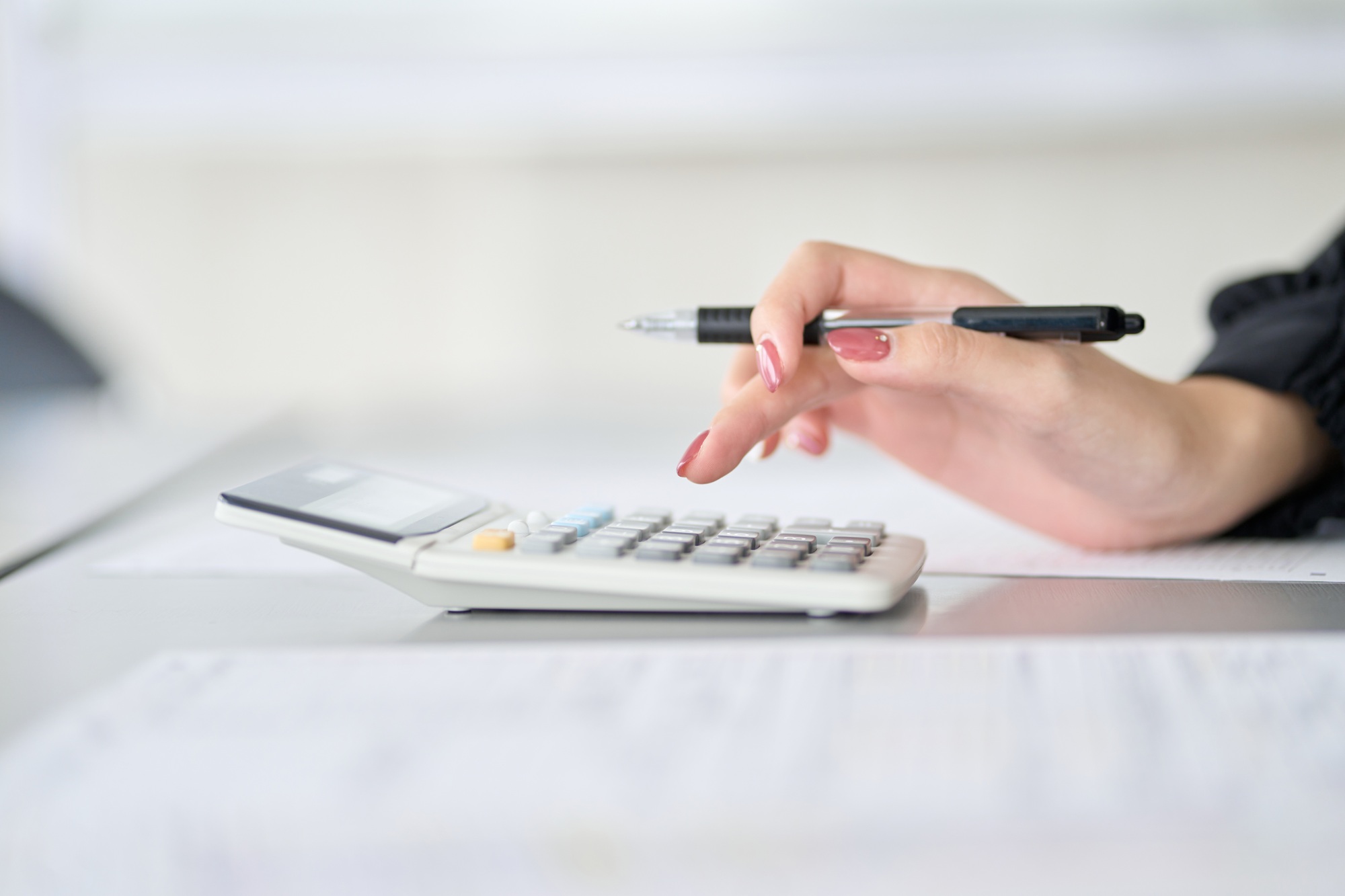 Asian woman calculating tax with calculator