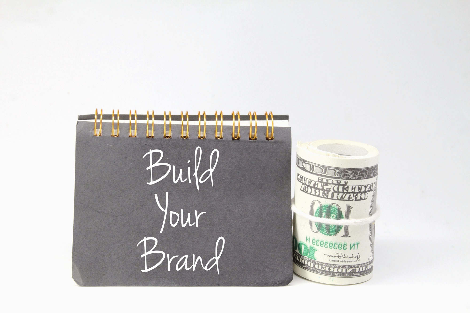 banknotes and books with the word build your brand.