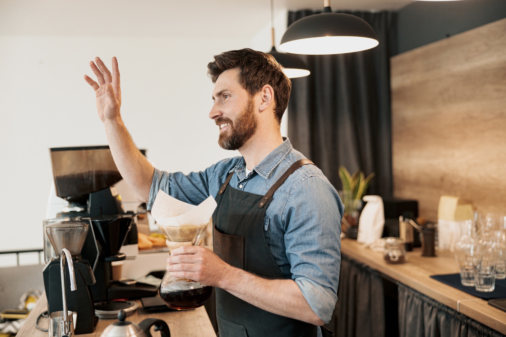 Barista joyfully greets a loyal customer while holding a ready-made coffee filter