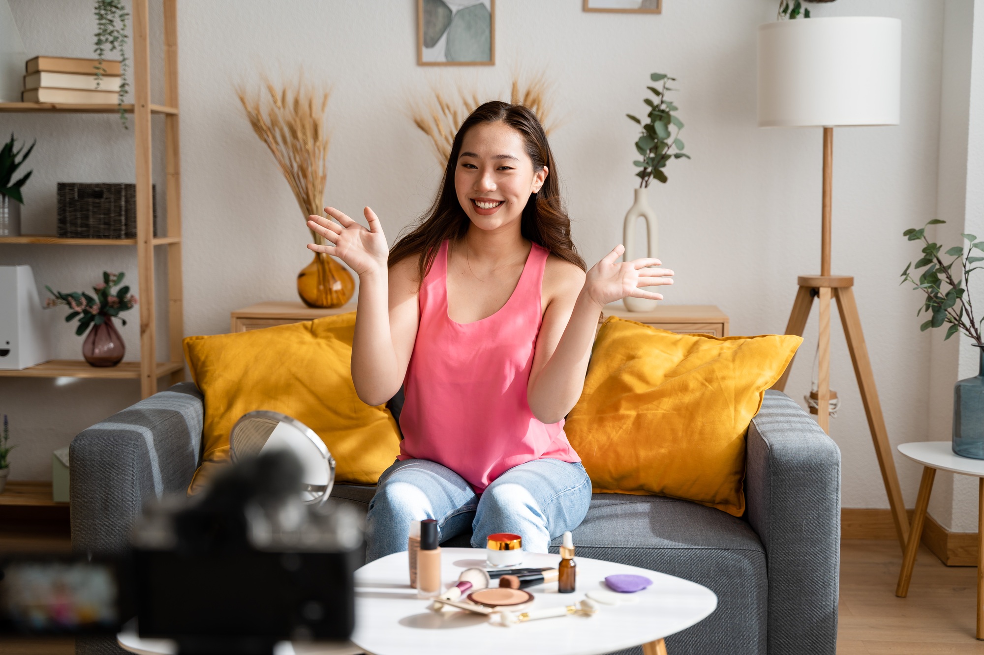 Beautiful young woman shooting makeup video tutorial at home.