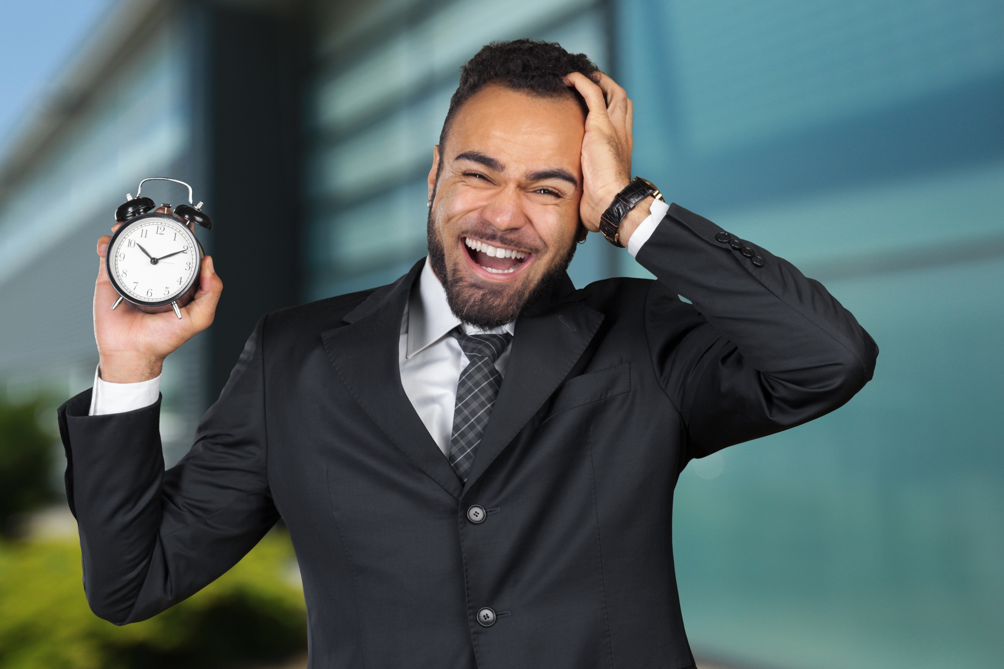 Black businessman with alarm clock. Time management concept
