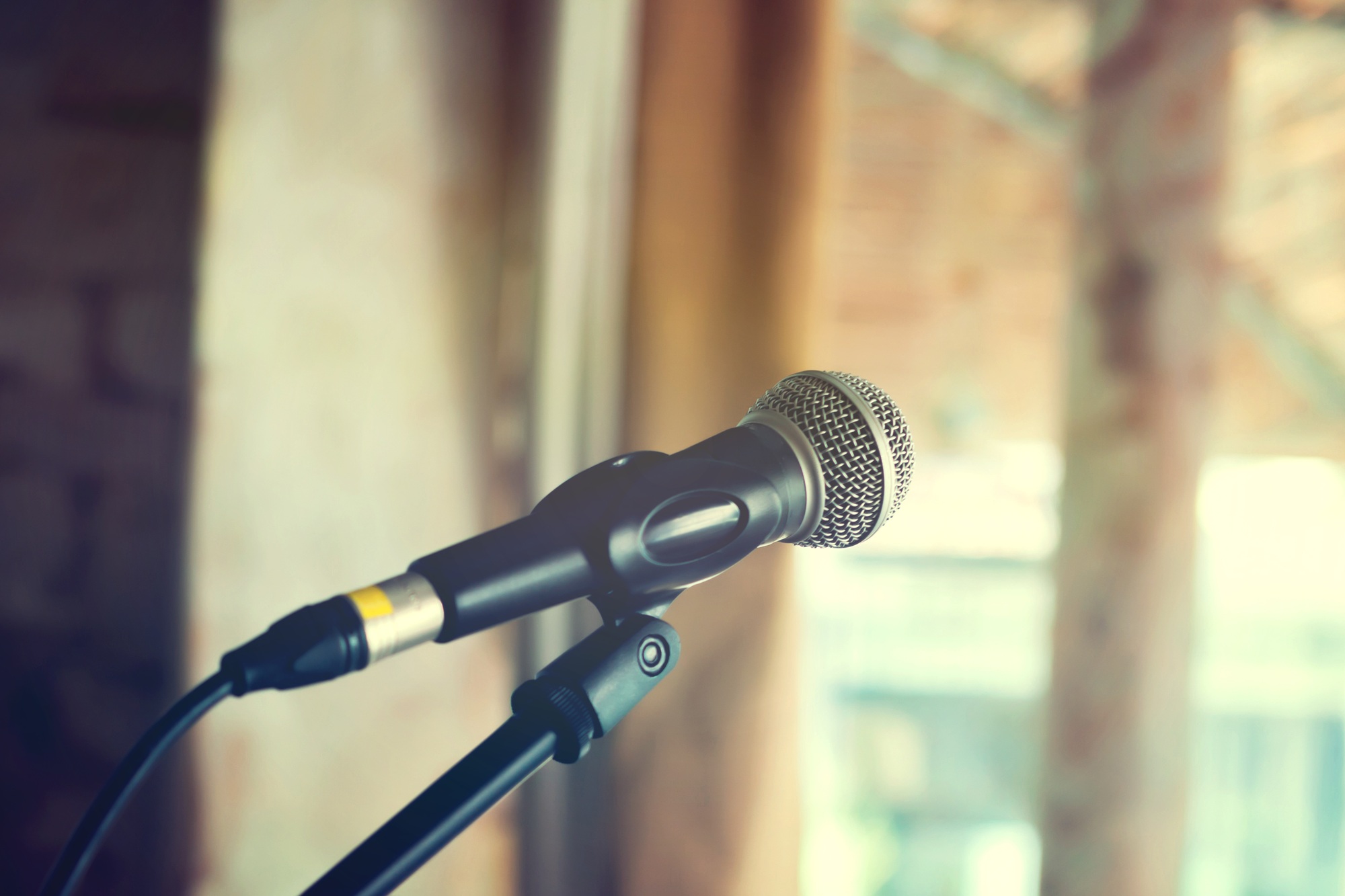 Black vintage mic on indoor stage -in vintage tone (selective focus)