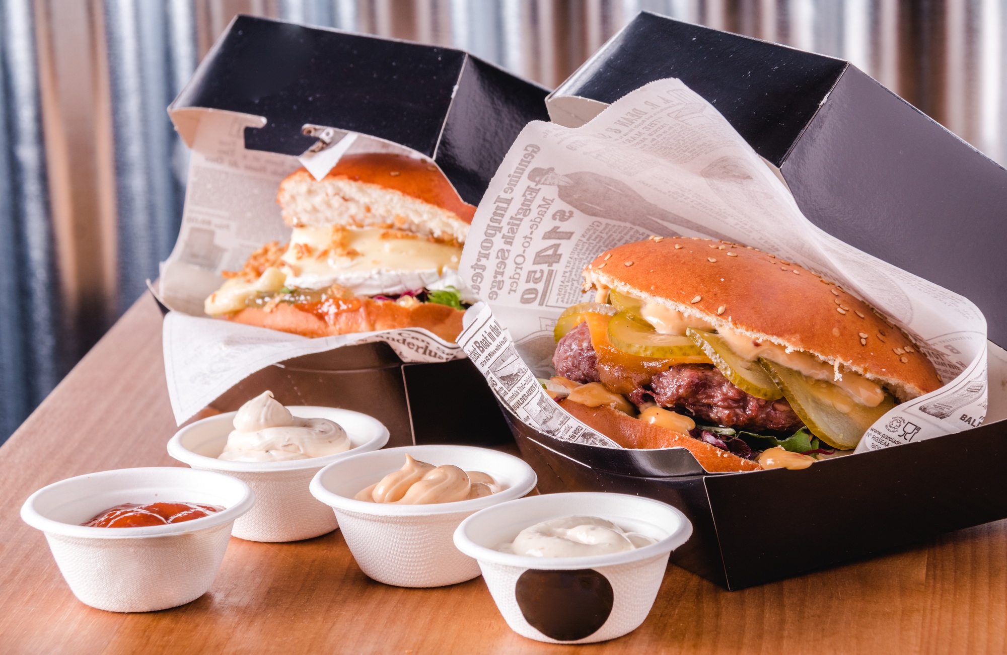 Burgers and dip sauces in takeaway containers. Fast food delivery concept