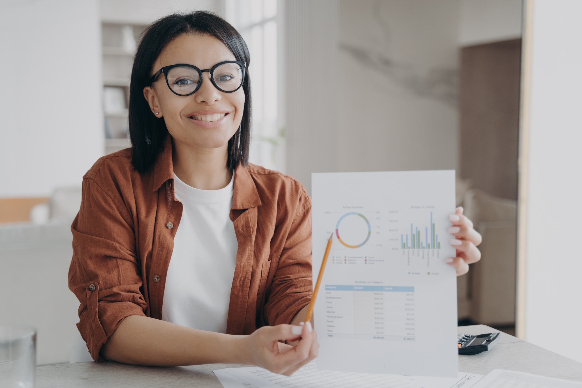 Business assistant points to the statistical data graph with pencil. Paperwork at home.