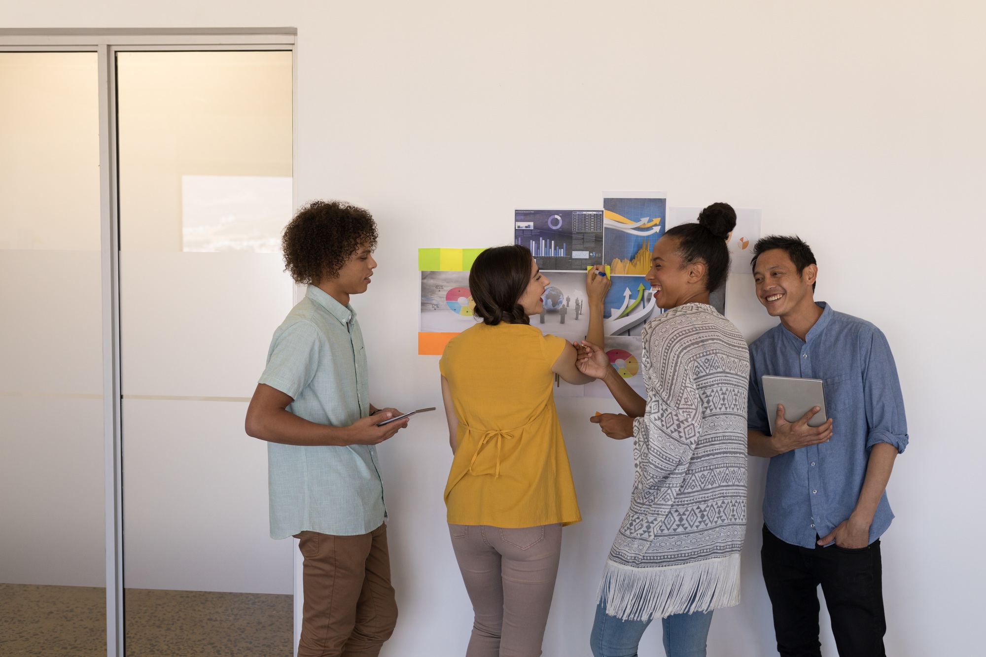 Business colleagues discussing company growth strategies over graphs and sticky notes in office