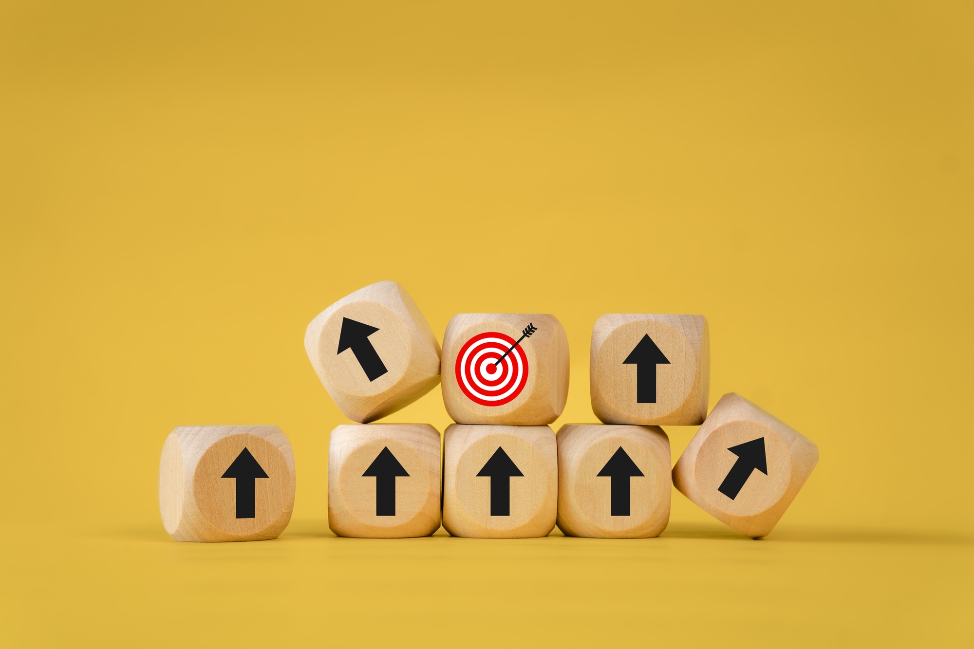 Business growth goals and success goals Scattered wooden blocks with arrow icons