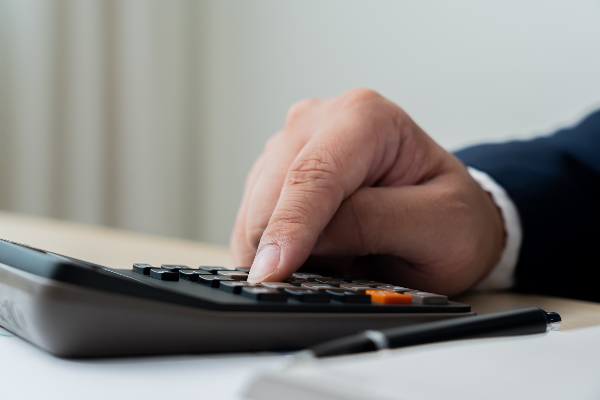Business man calculating financial budget using calculator