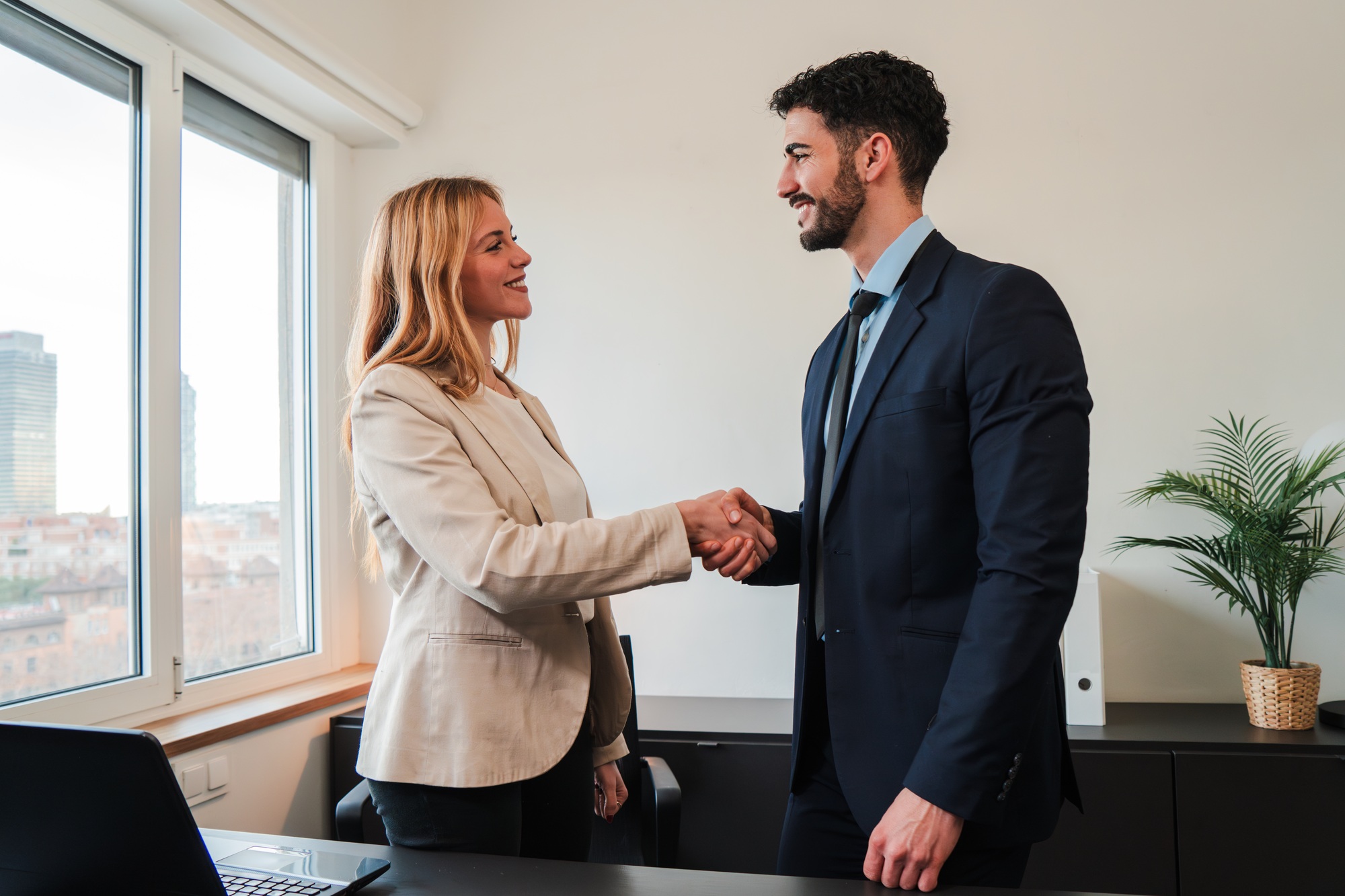 Business Meeting: Two Professionals or Coworkers Engaging in a Friendly Handshake in a Modern Office