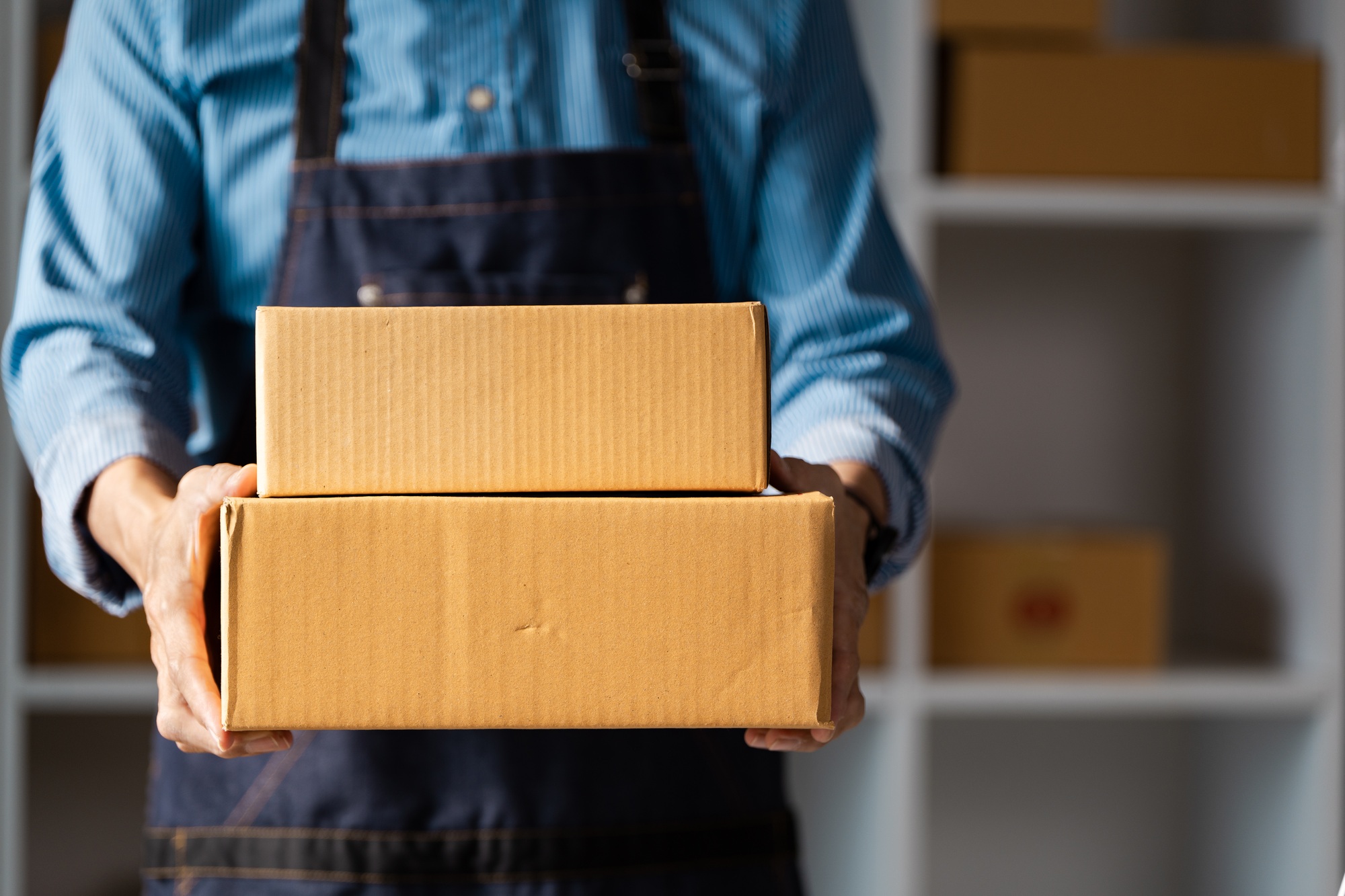 Business owner carrying packages for online delivery, showcasing commitment to customer service.