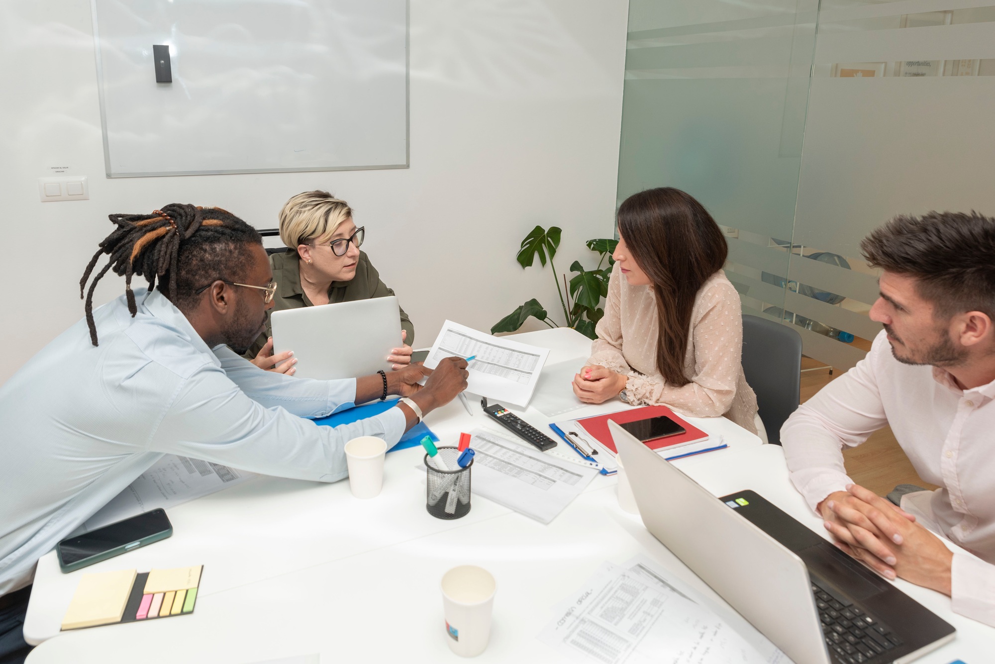 Business people analyze data from financial documents in meeting