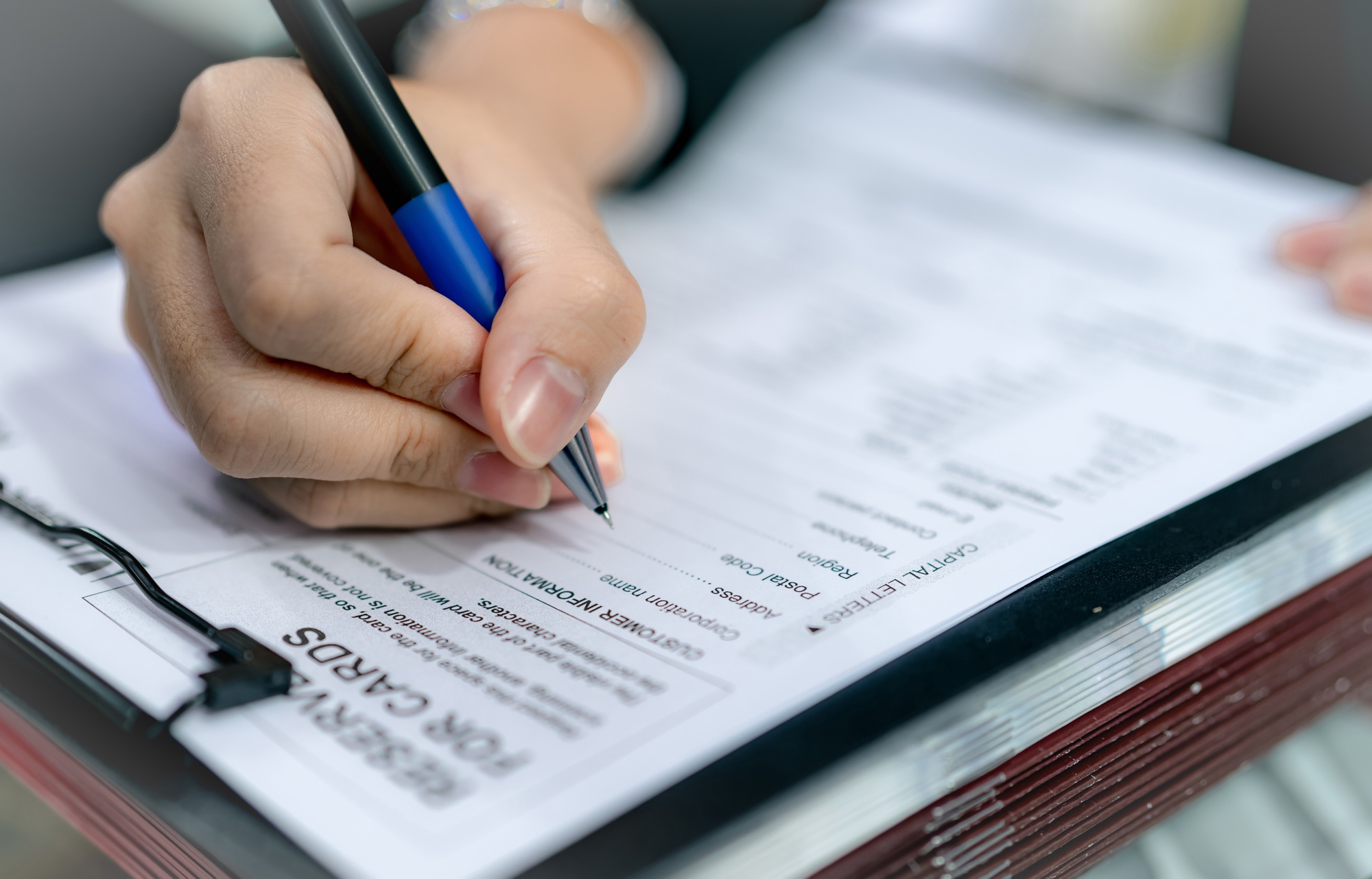 Business people hand holding pen and fill corporation profile in paper form for contract agreement.