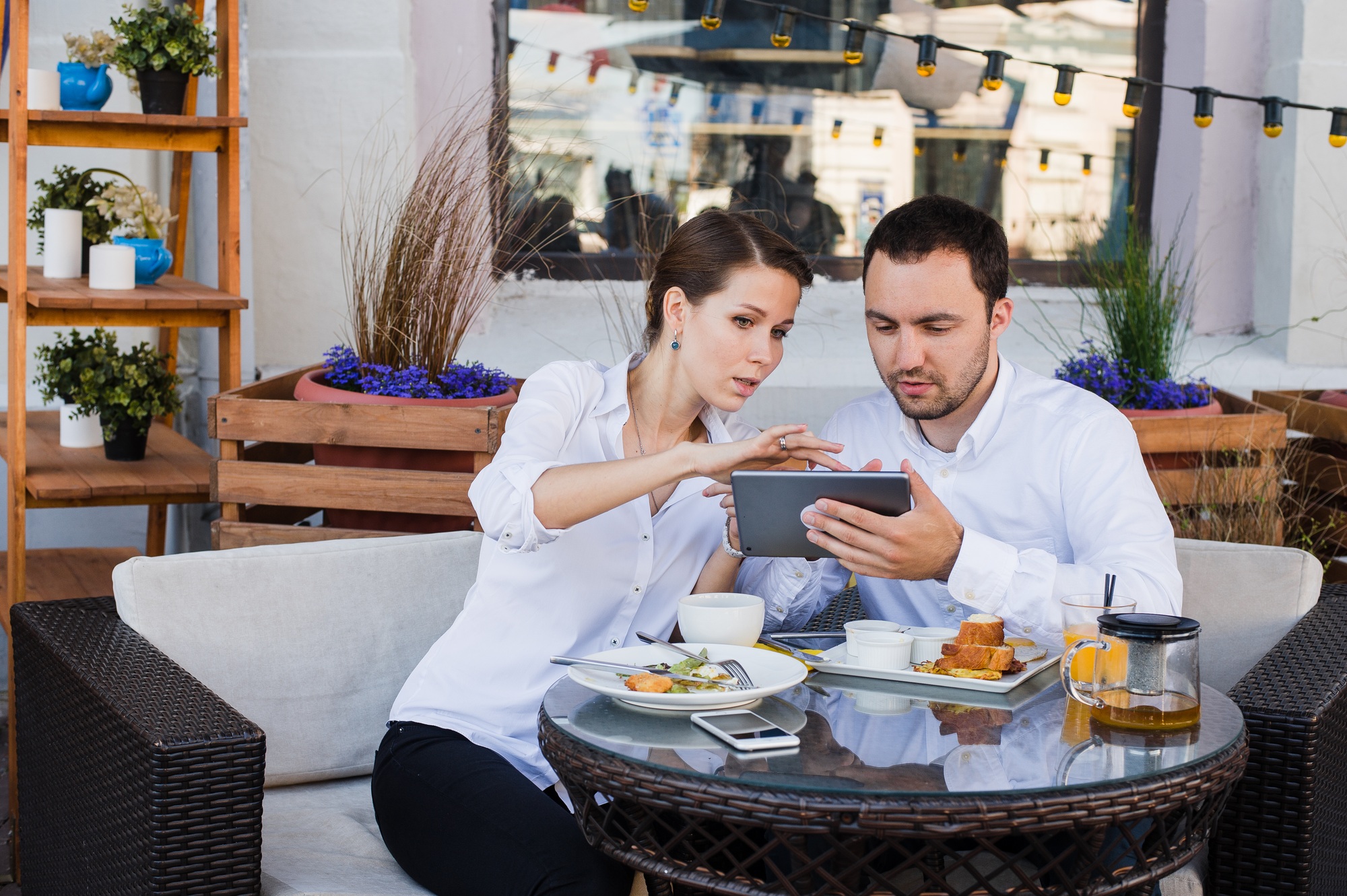 Business people looking at digital tablet in cafe during a meeting