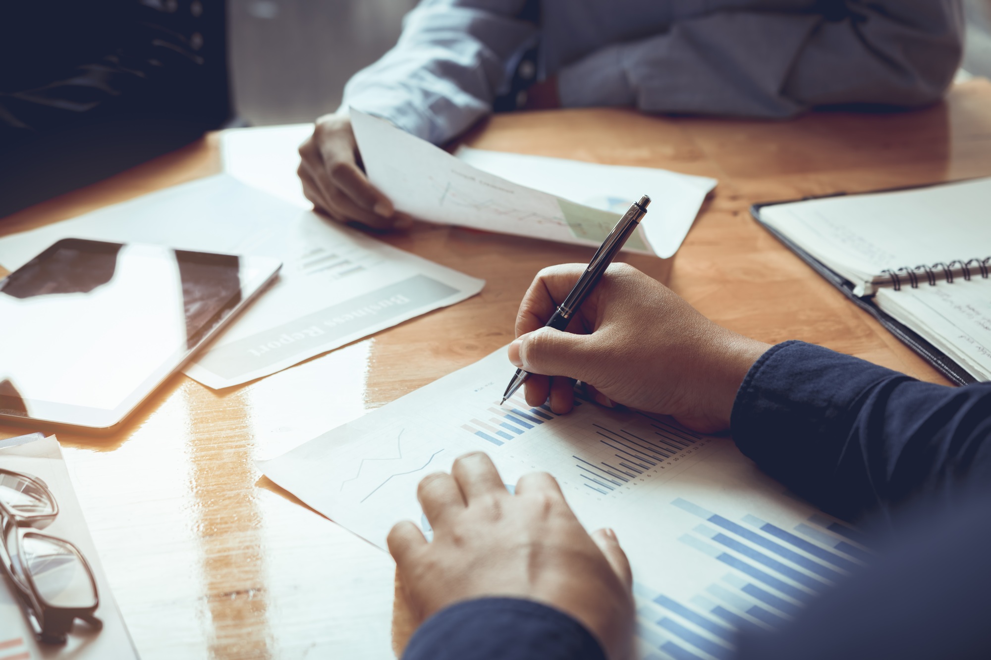 Business people working on table and checking statistics chart data on sales development.