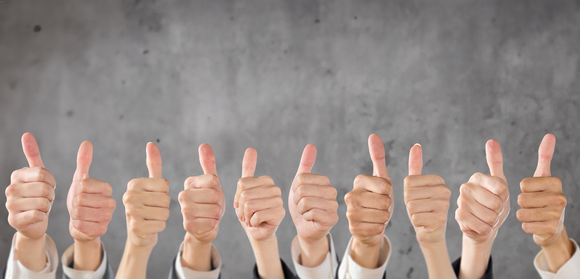 Business person giving good sign on concrete background