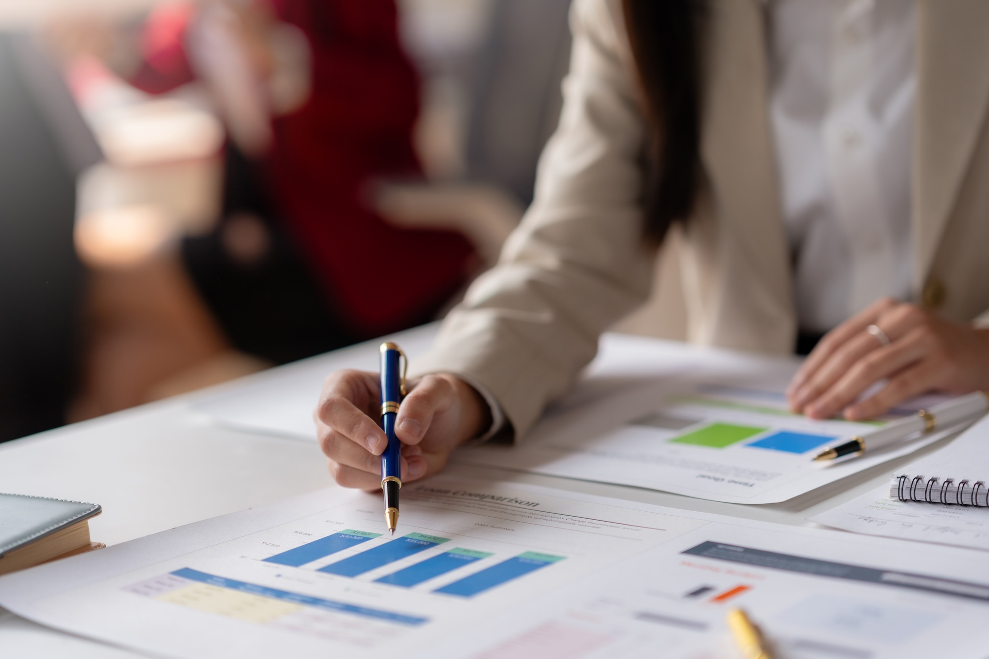 Business professional analyzing financial charts and data at office desk during a meeting