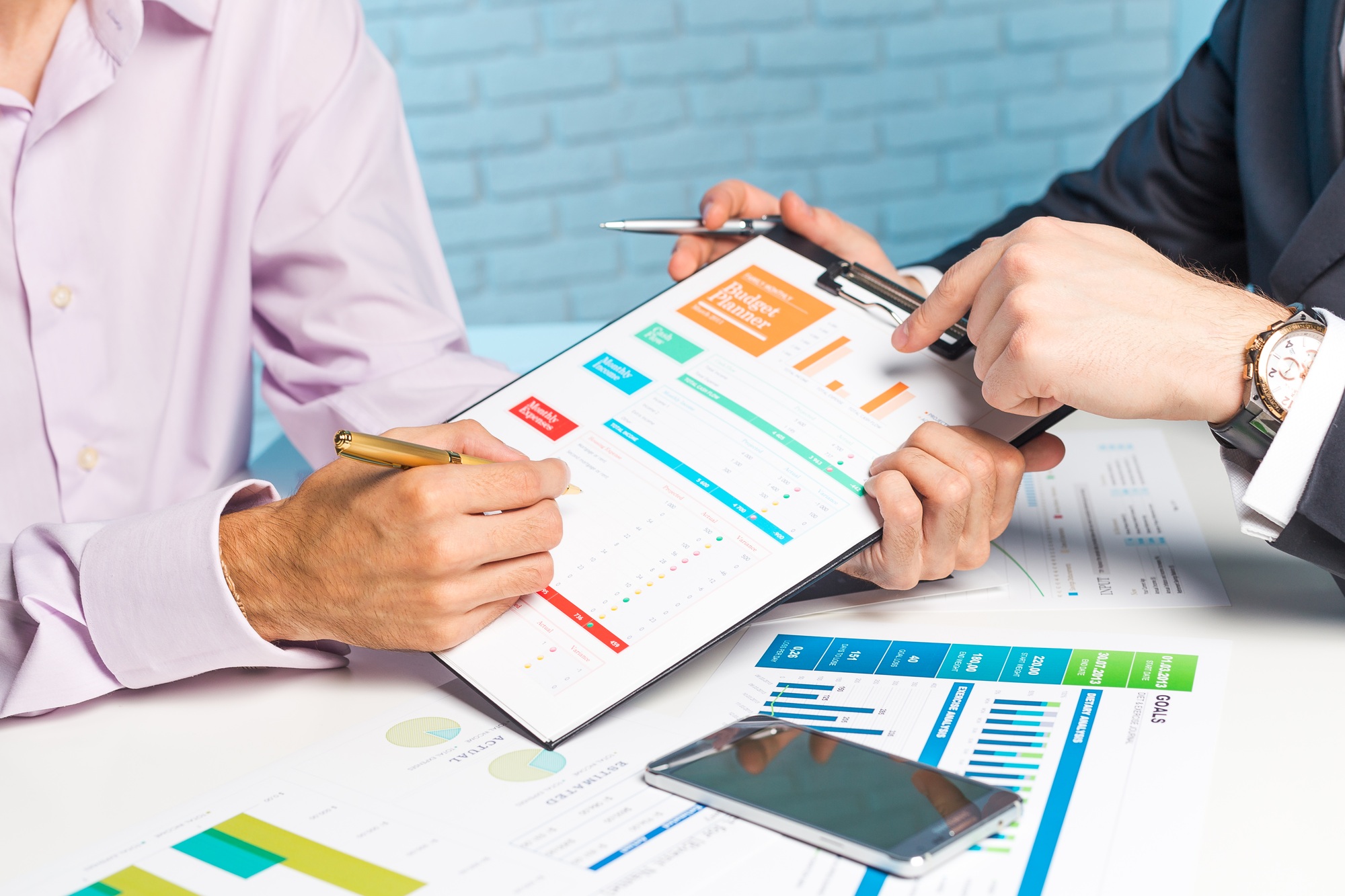 Business professionals discussing financial reports at a meeting table using charts and graphs to
