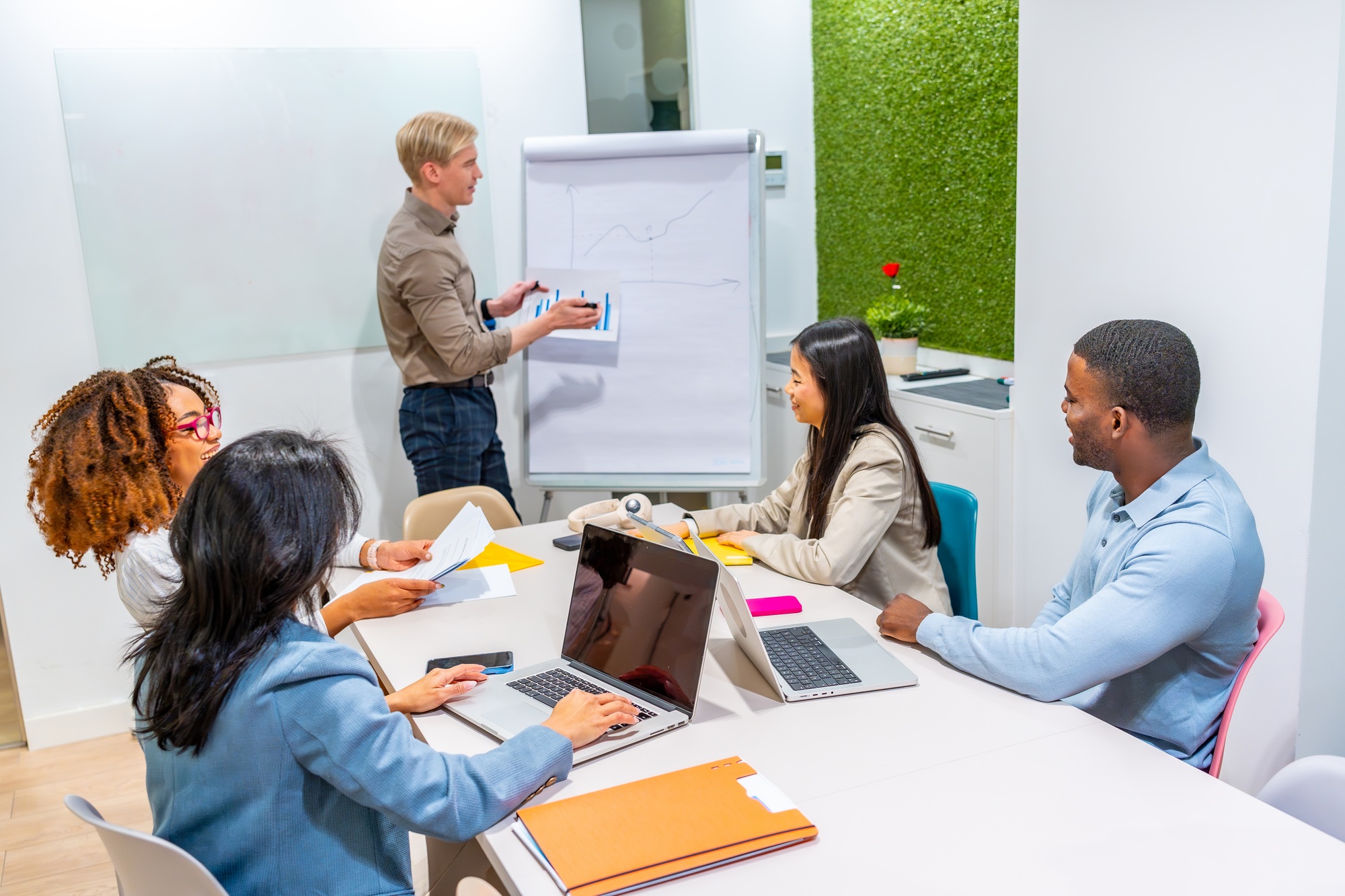Business team meeting in coworking office analyzing charts and growth