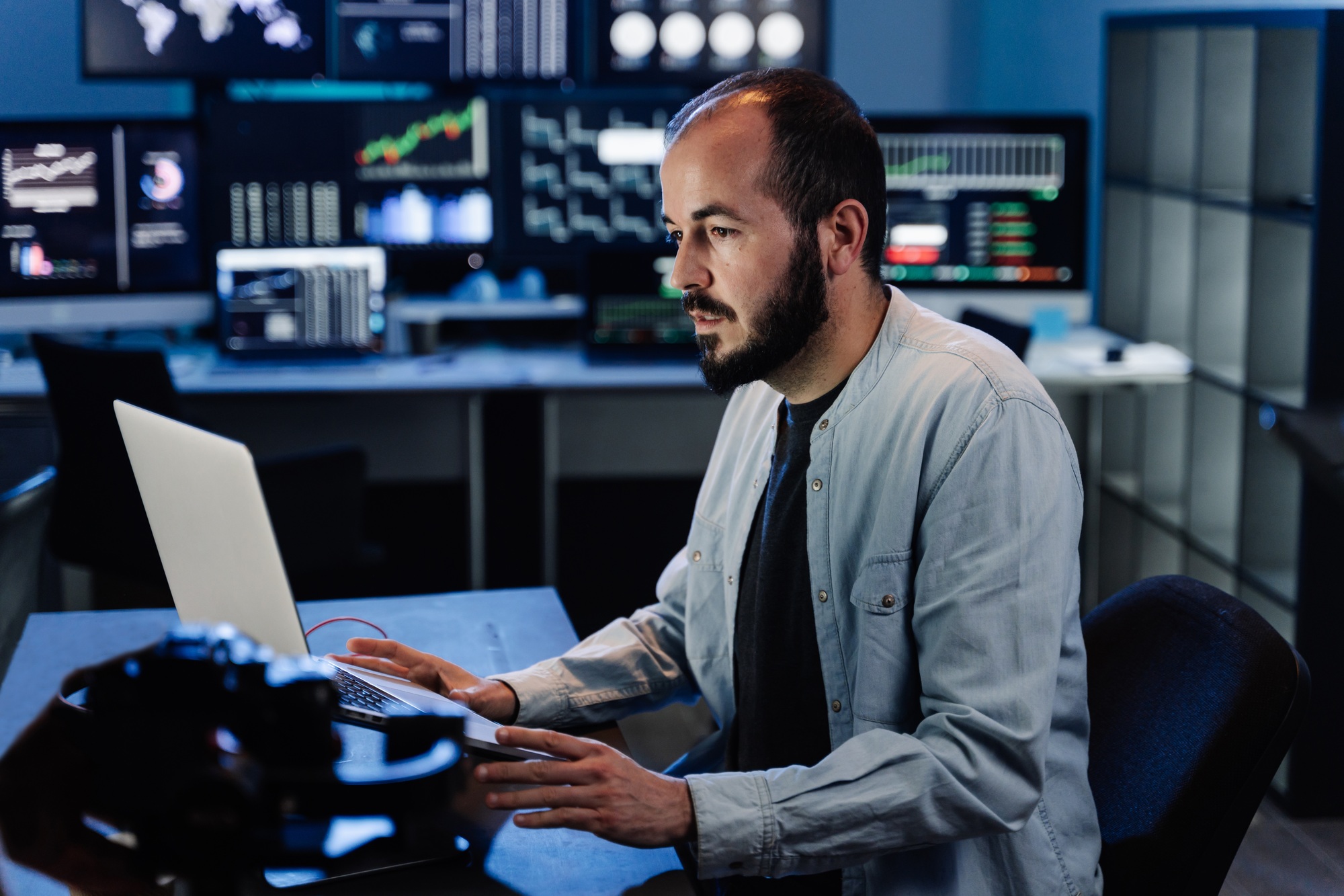 Business Trading Man sitting at desk at office working on laptop monitoring market exchange