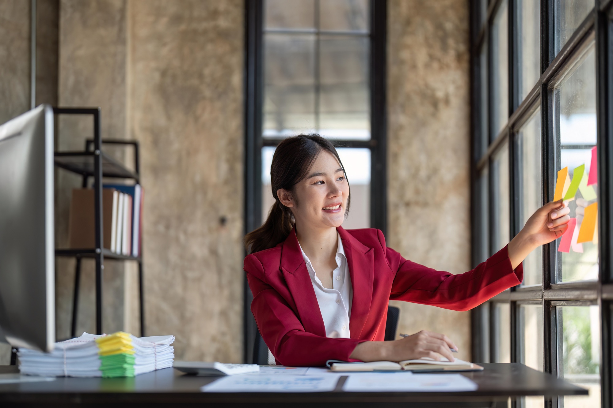 Business woman analyzing process schedule, planning tasks on colorful sticky notes