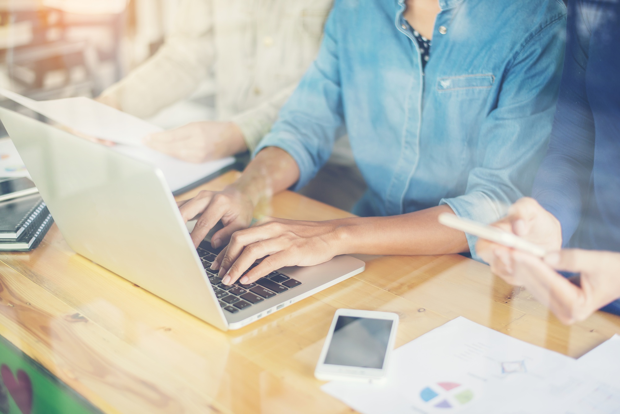 business woman hand working on smart phone and laptop computer and business graph information