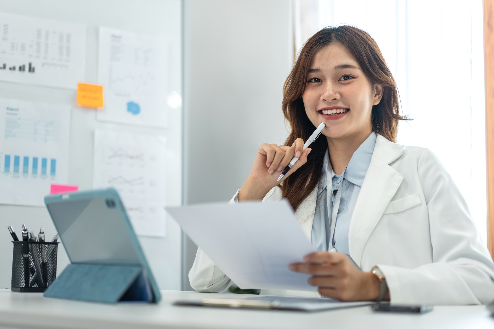 business woman is working on tablet and holding financial document to contemplating the strategy