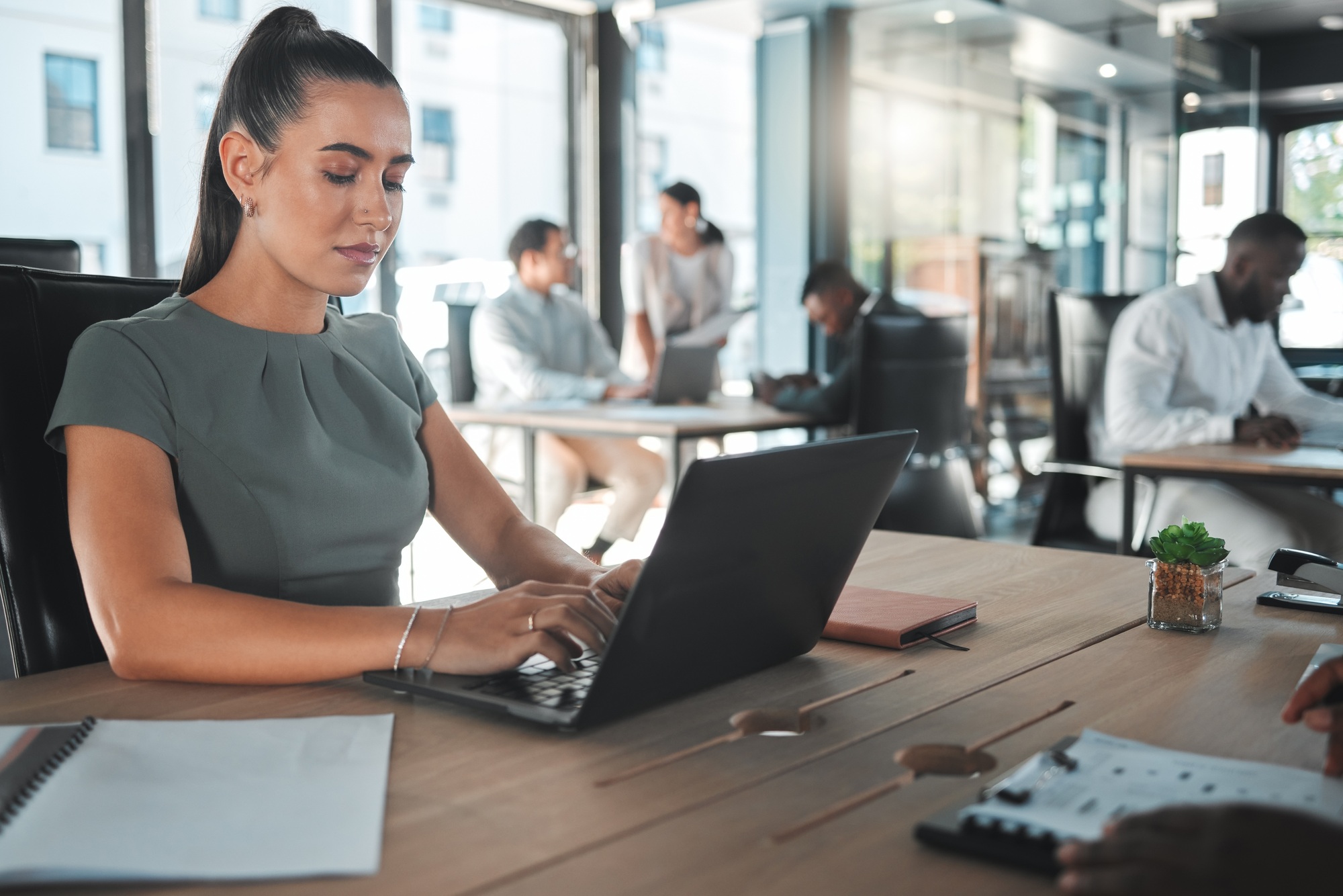 Business woman on a computer at a startup company, working on email. Girl in corporate management a