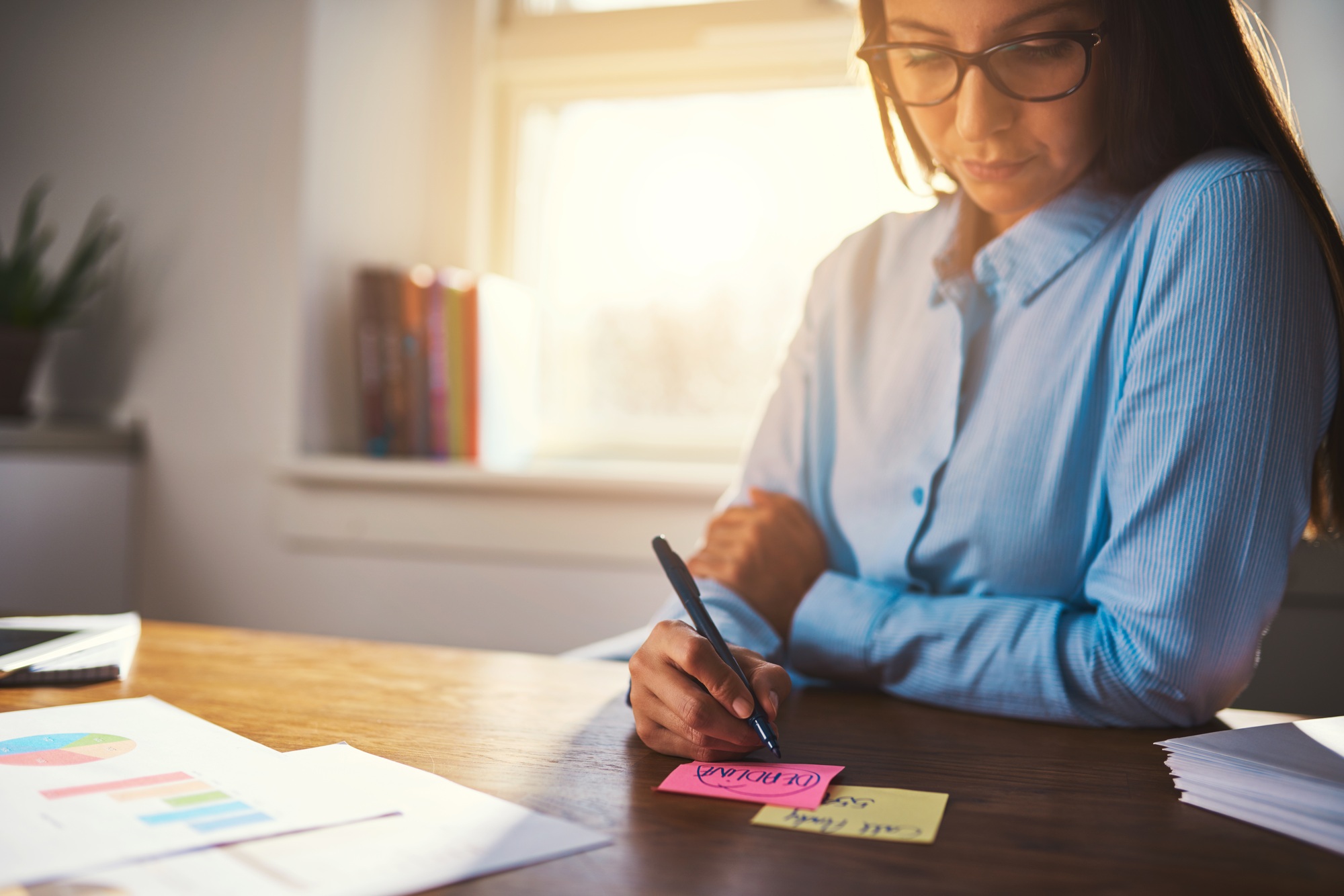 Business woman writing notes on post it