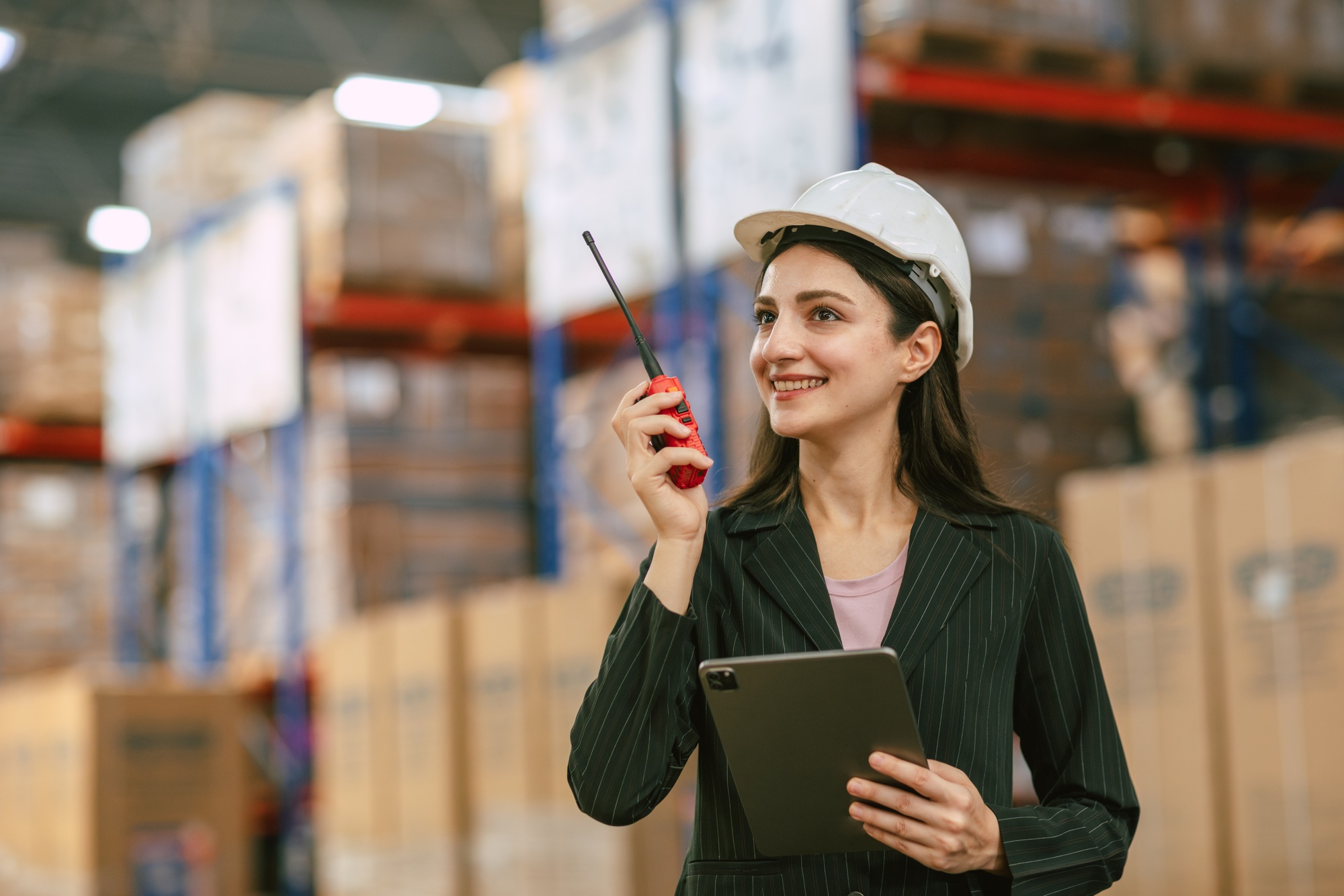 Business women working in cargo warehouse manage operating control products inventory with radio