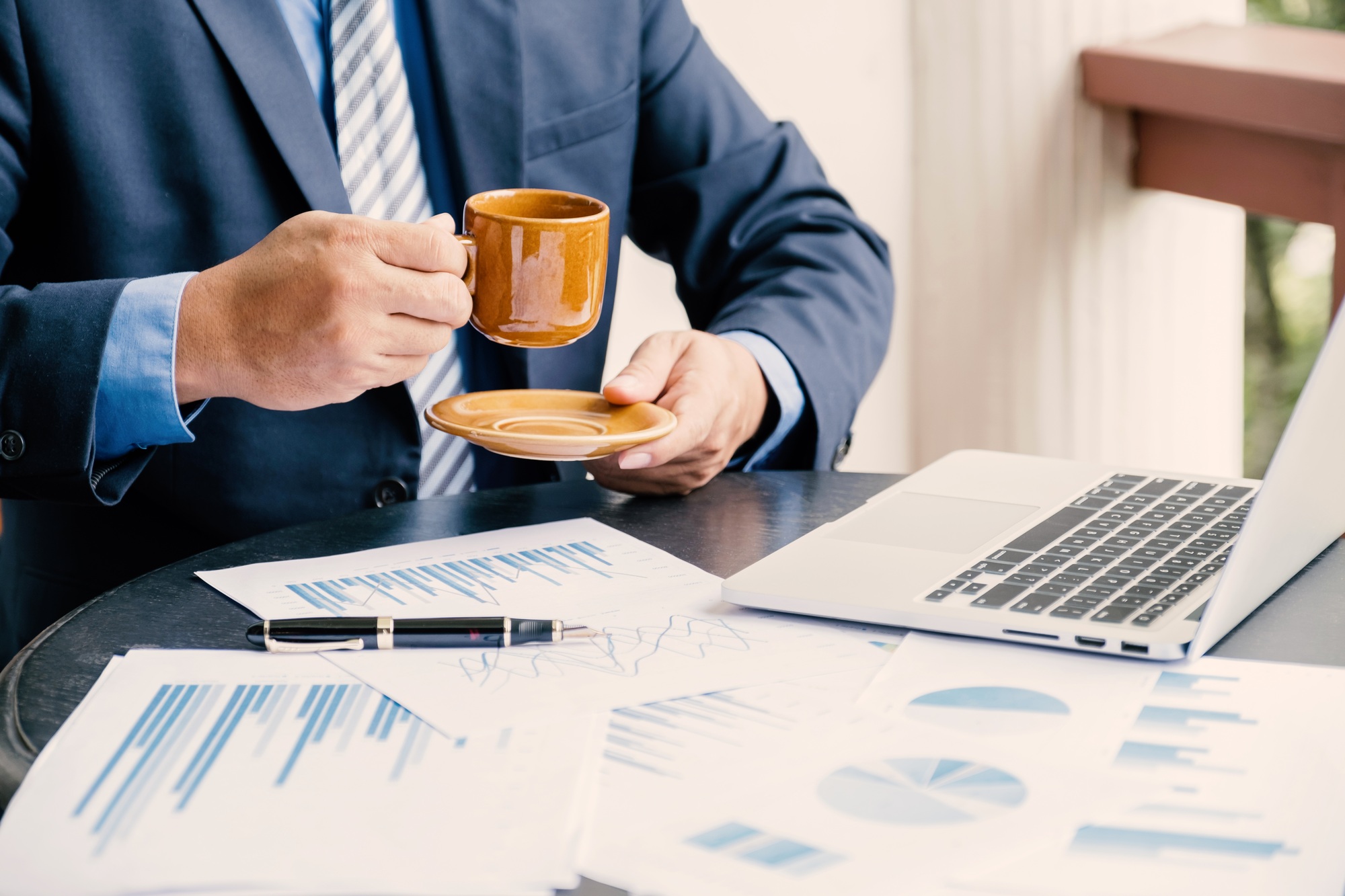 Businessman analysis the graph with laptop at home office for setting challenging business goals