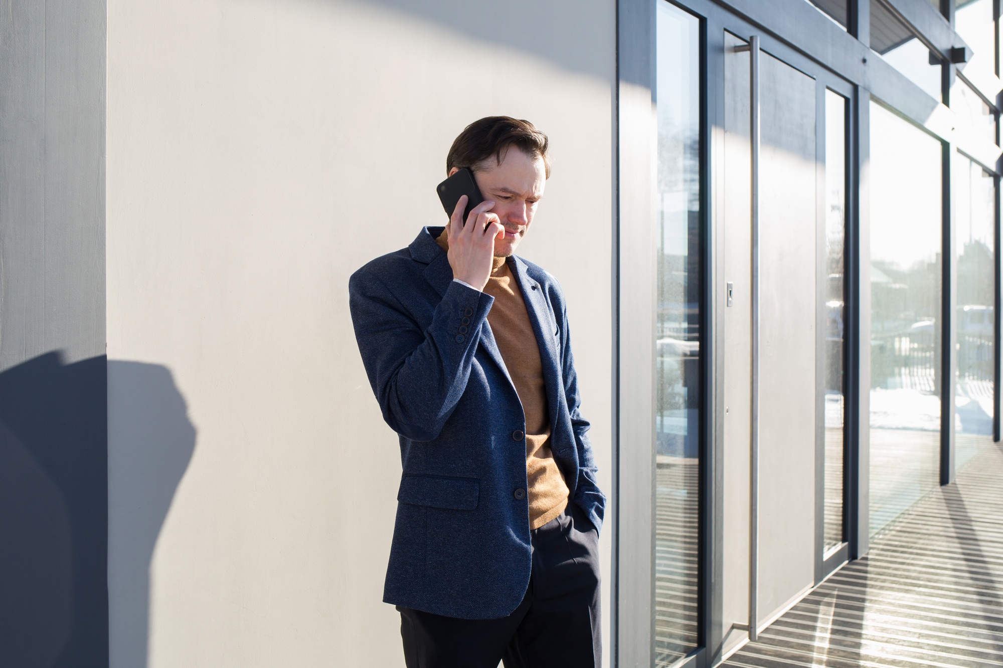 businessman man calls talking on phone background of modern house or building