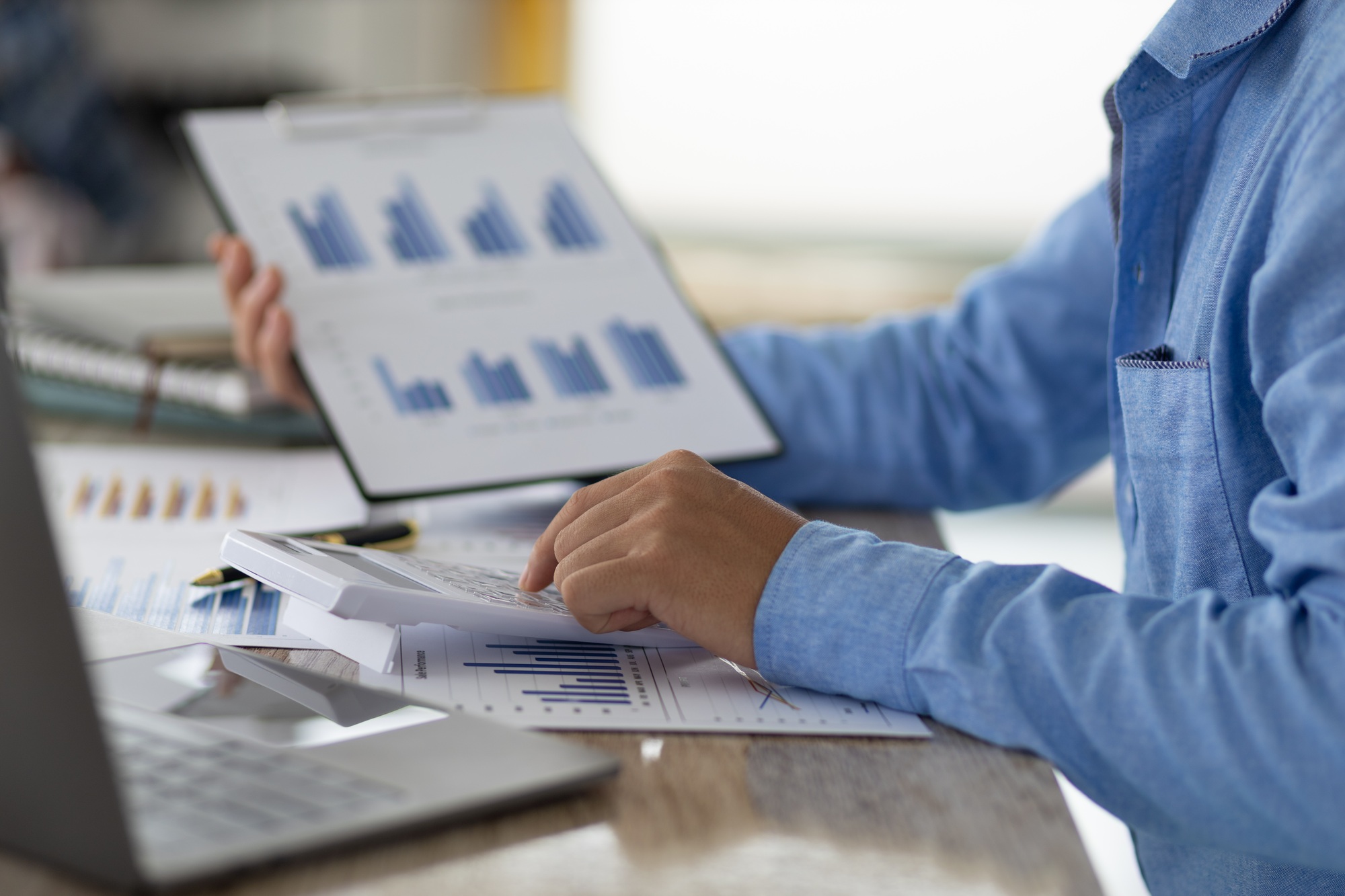 Businessman pointing at chart in document analyzing company sales and financial reports.