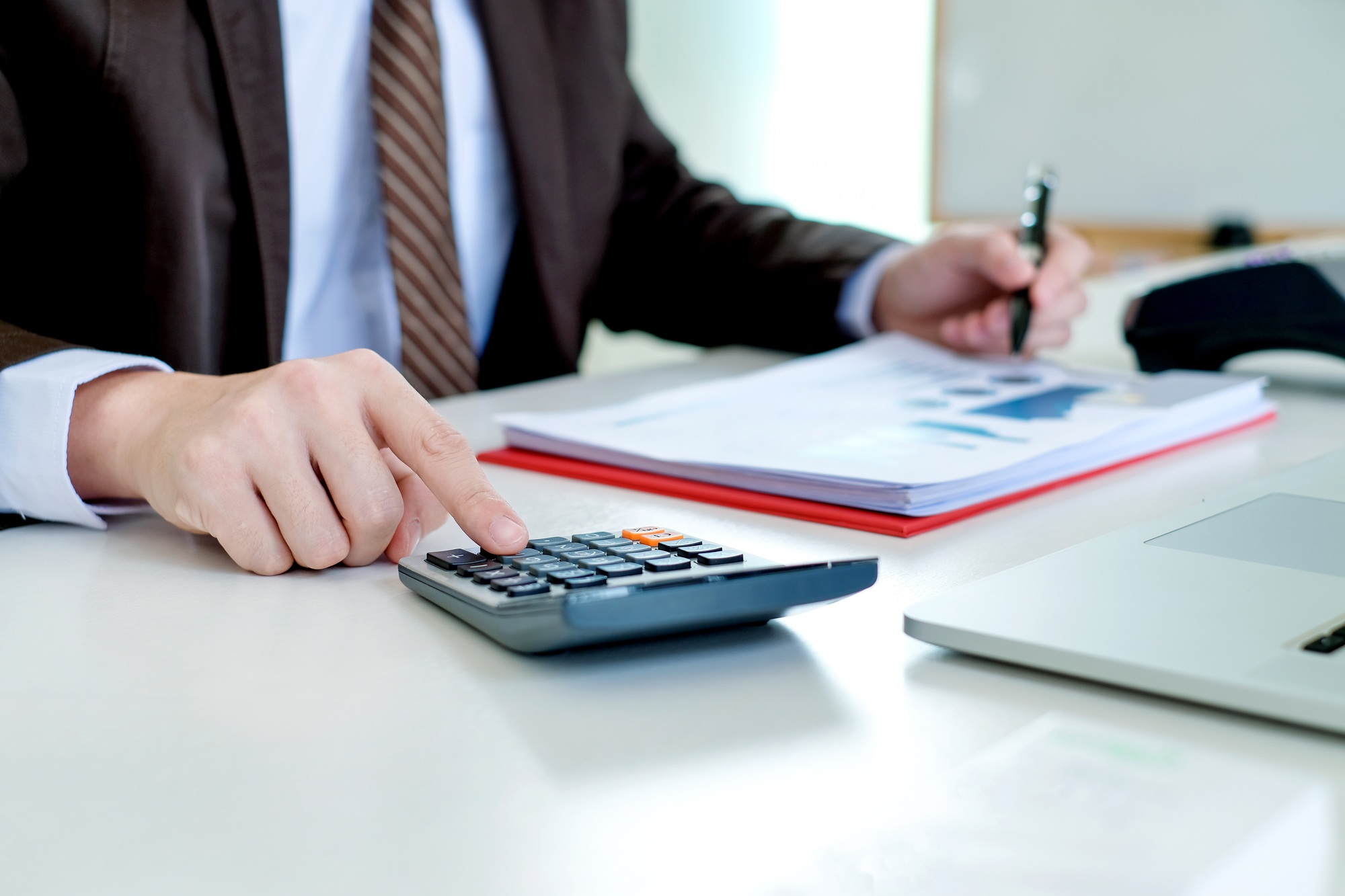 Businessman using calculator working at office with reports document financial.