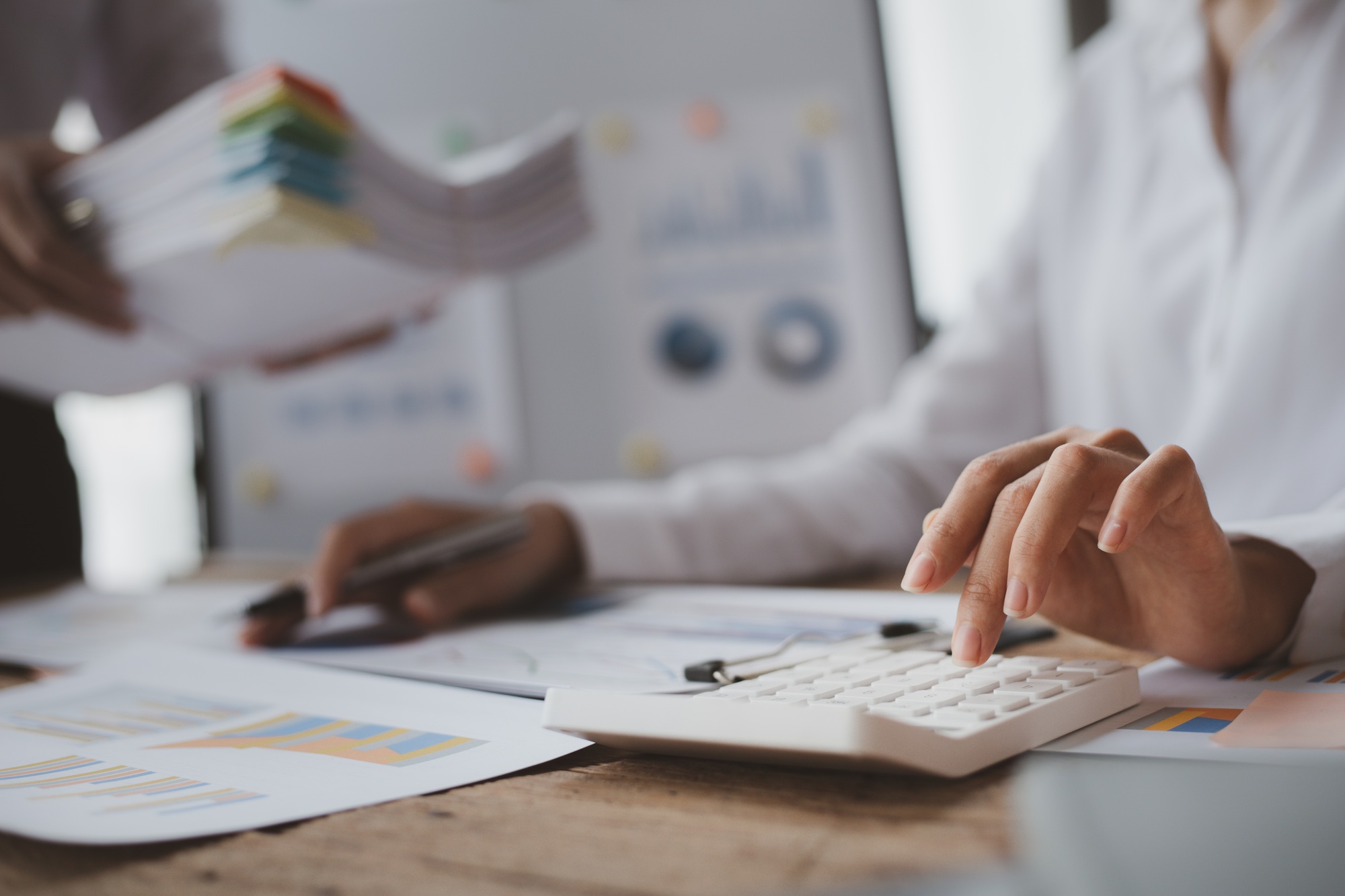 Businessmen are opening up their laptop's financial information for business partnerships.