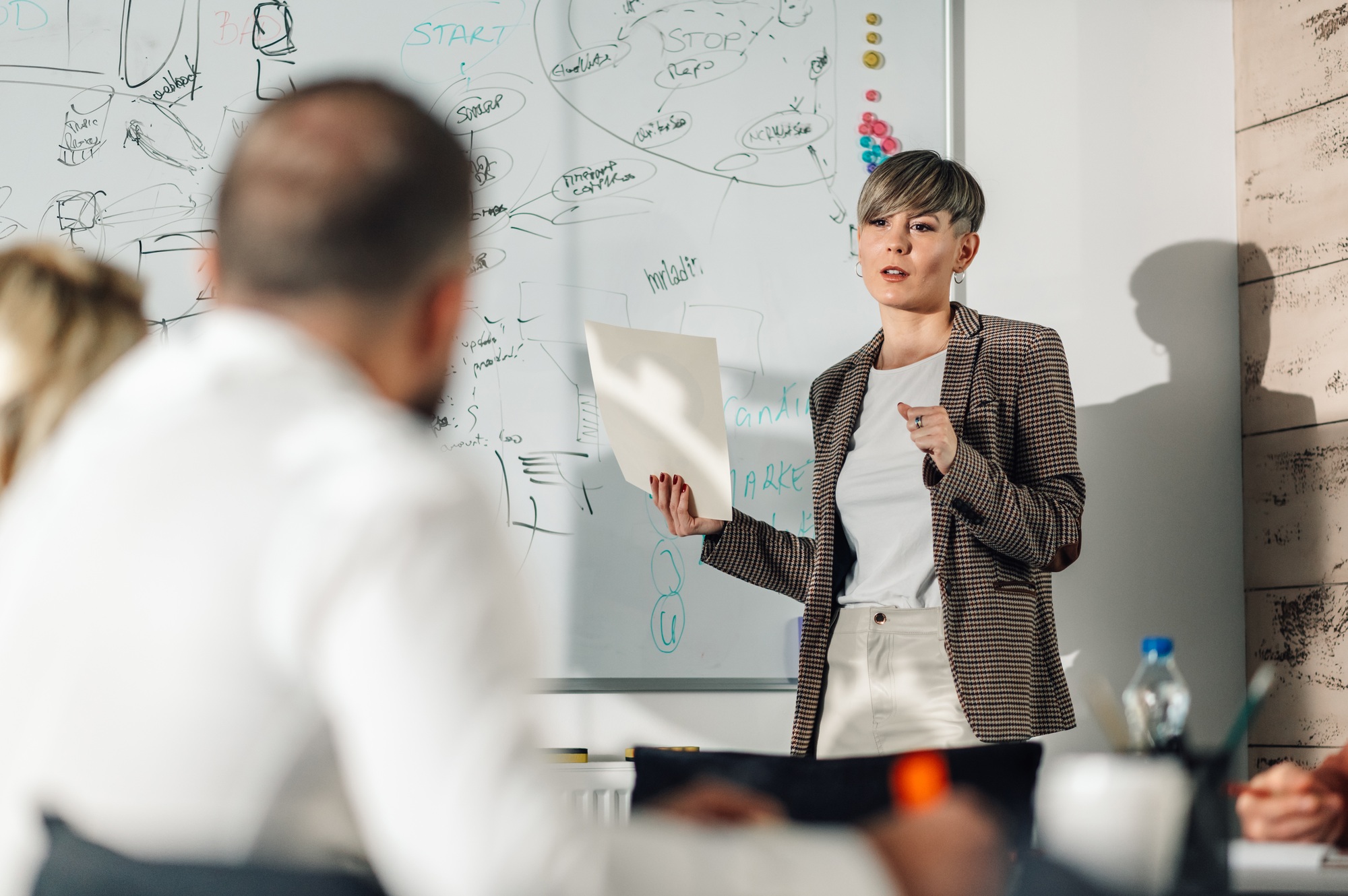 Businesswoman leading presentation, explaining strategy to colleagues in office meeting room
