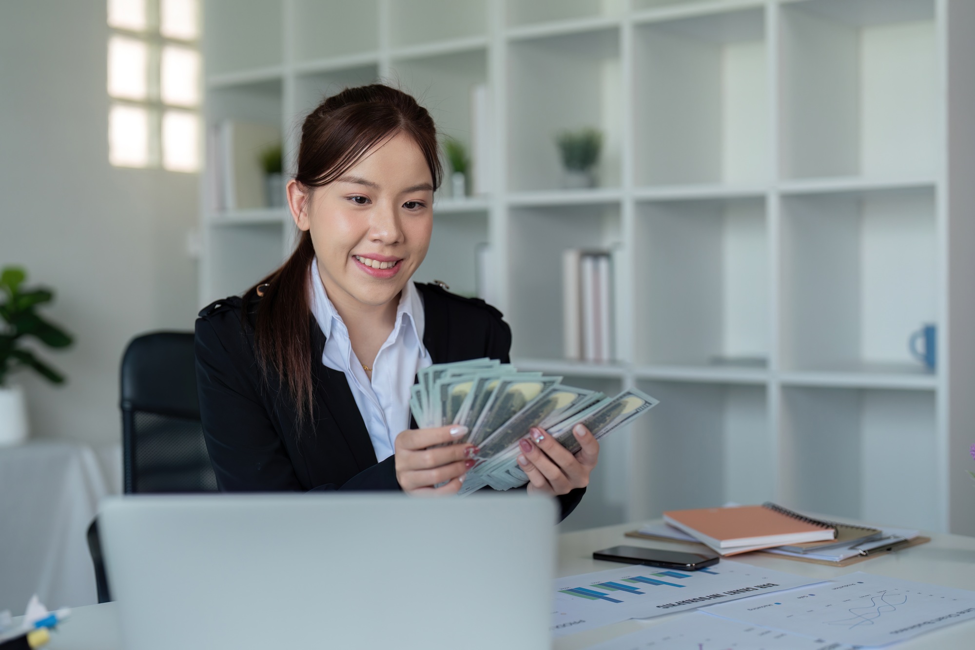 Businesswoman or financial bookkeeper holding bundle of money dollar for payment salary and income
