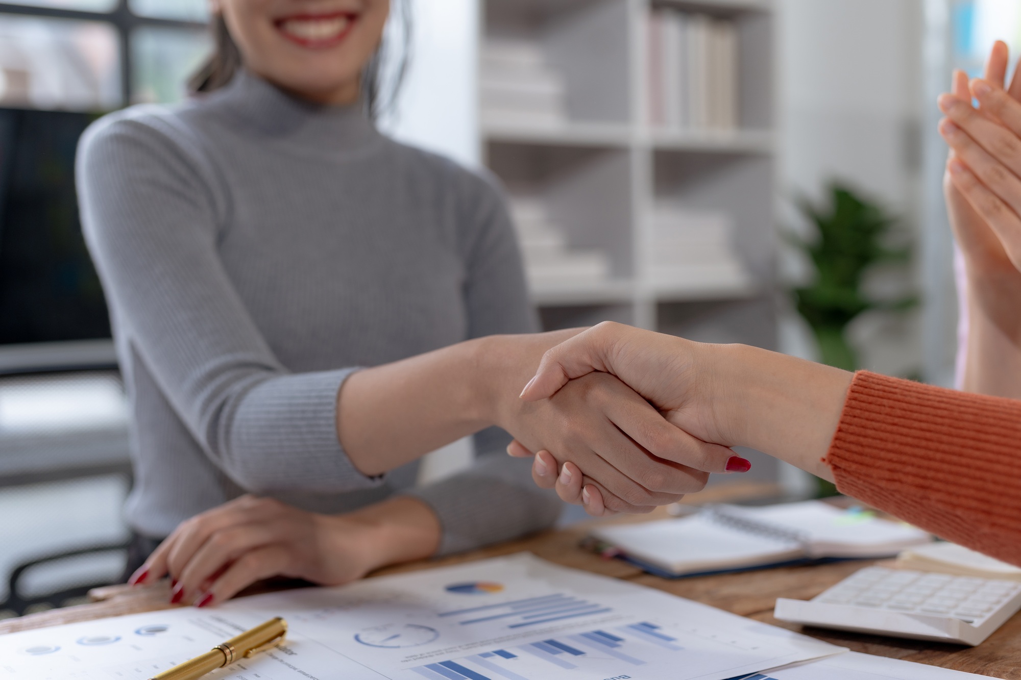 Businesswoman shake hand with partner to celebration partnership and business deal.