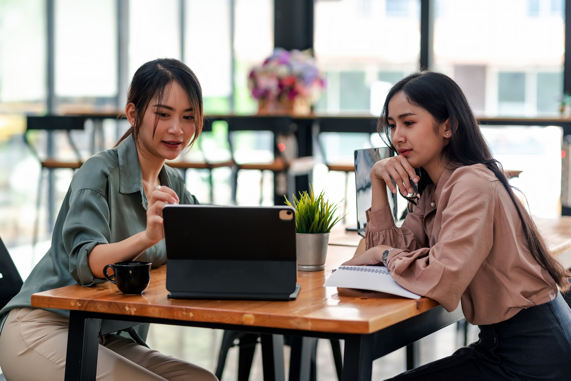 Businesswoman team find ideas collaboration using your tablet at a coffee shop.