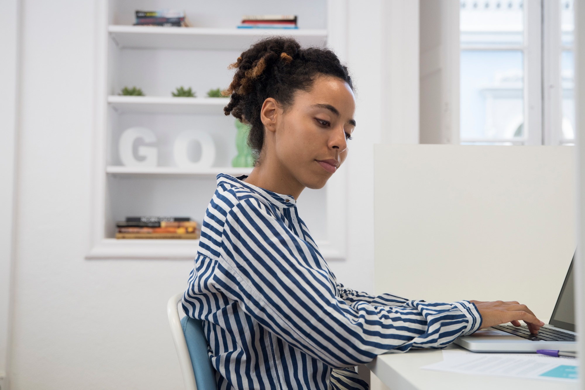 Businesswoman typing on laptop at office desk