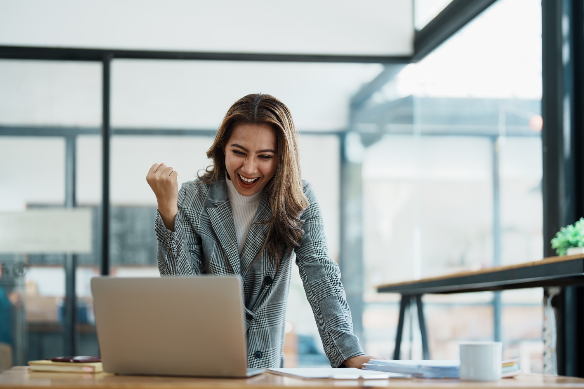 businesswoman using laptop Excited the work came out successfully and the goal was achieved