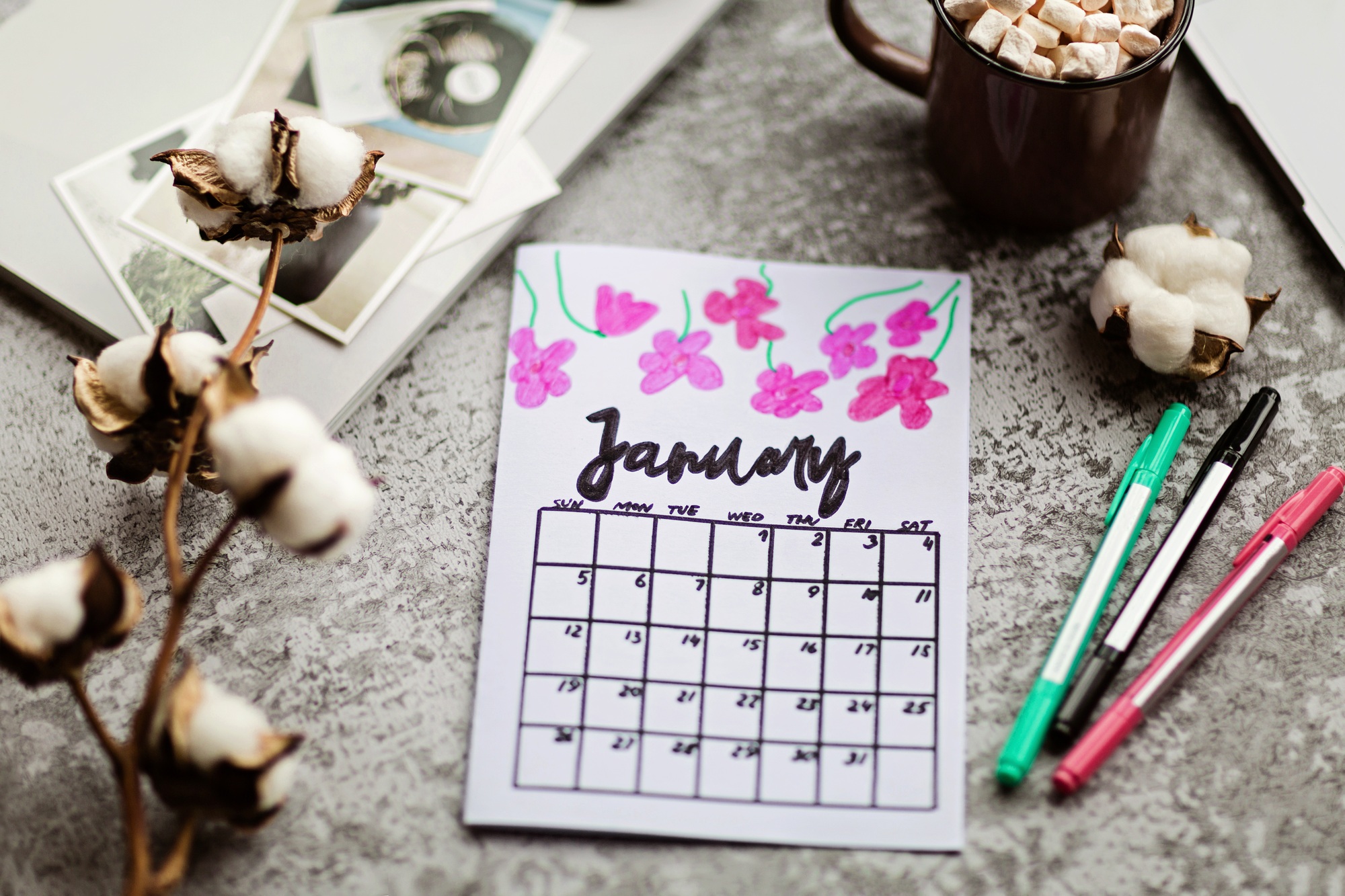 Calendar flat lay items on desk with laptop cotton flowers magazine lifestyle pen coffee cup mug