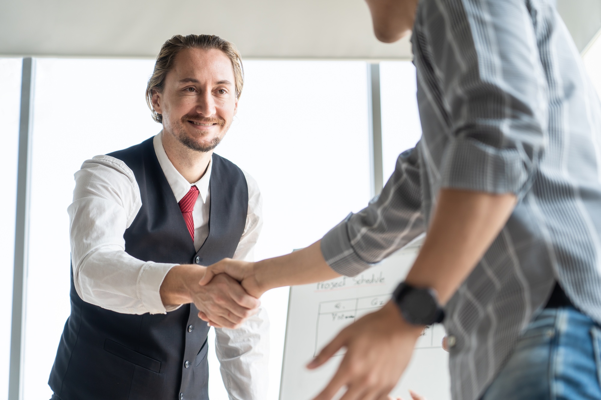 Caucasian businessman manager and Asian partnership client after having successful agreement