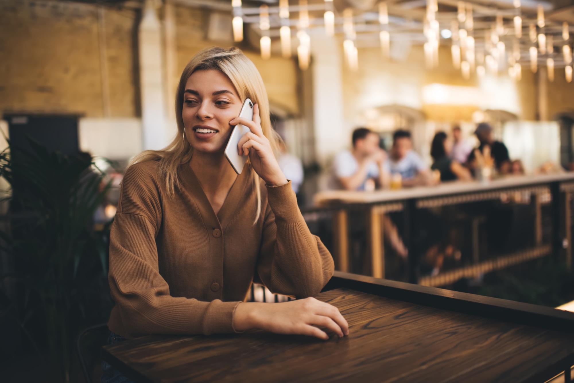 Caucasian woman phoning to friend while using internet connection during weekend pastime