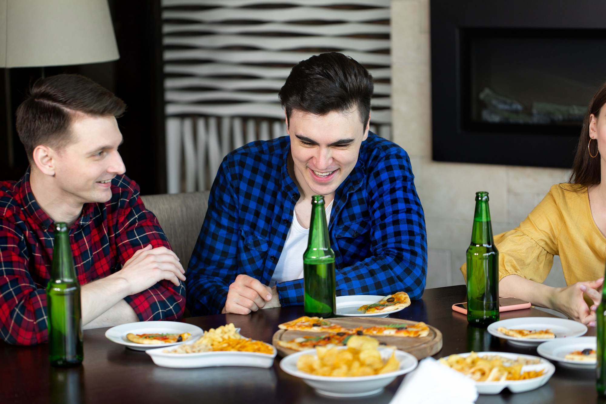 Celebrating success. Young cheerful people smile and celebrates success while resting in pub.