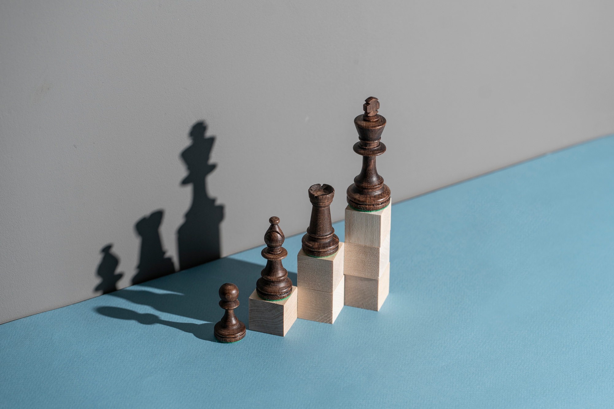 chess pieces on the wooden cubes making growing graph, team leadership