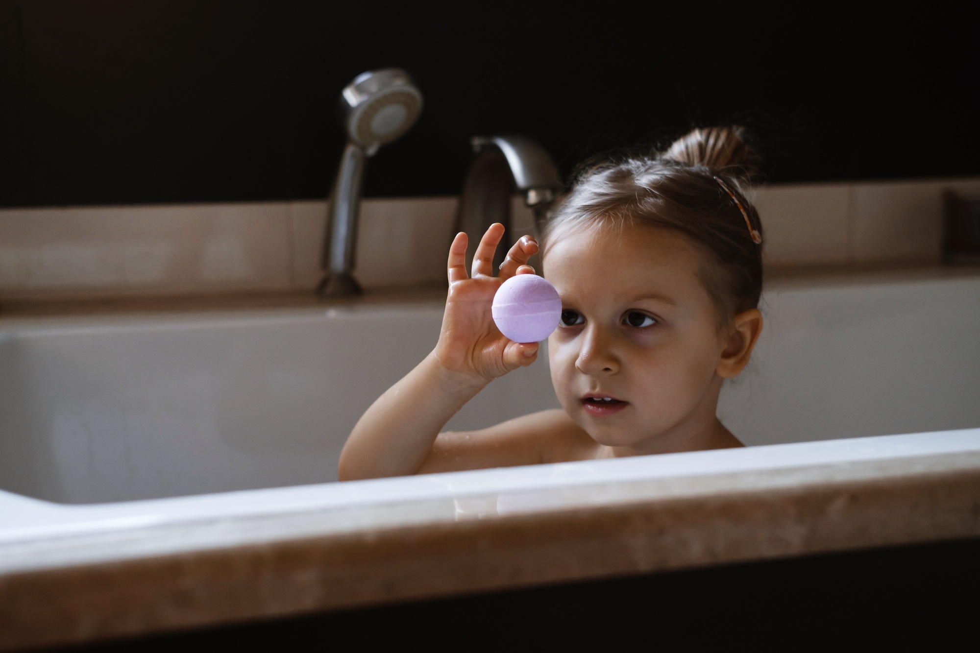 Child holding aromatic bath bomb