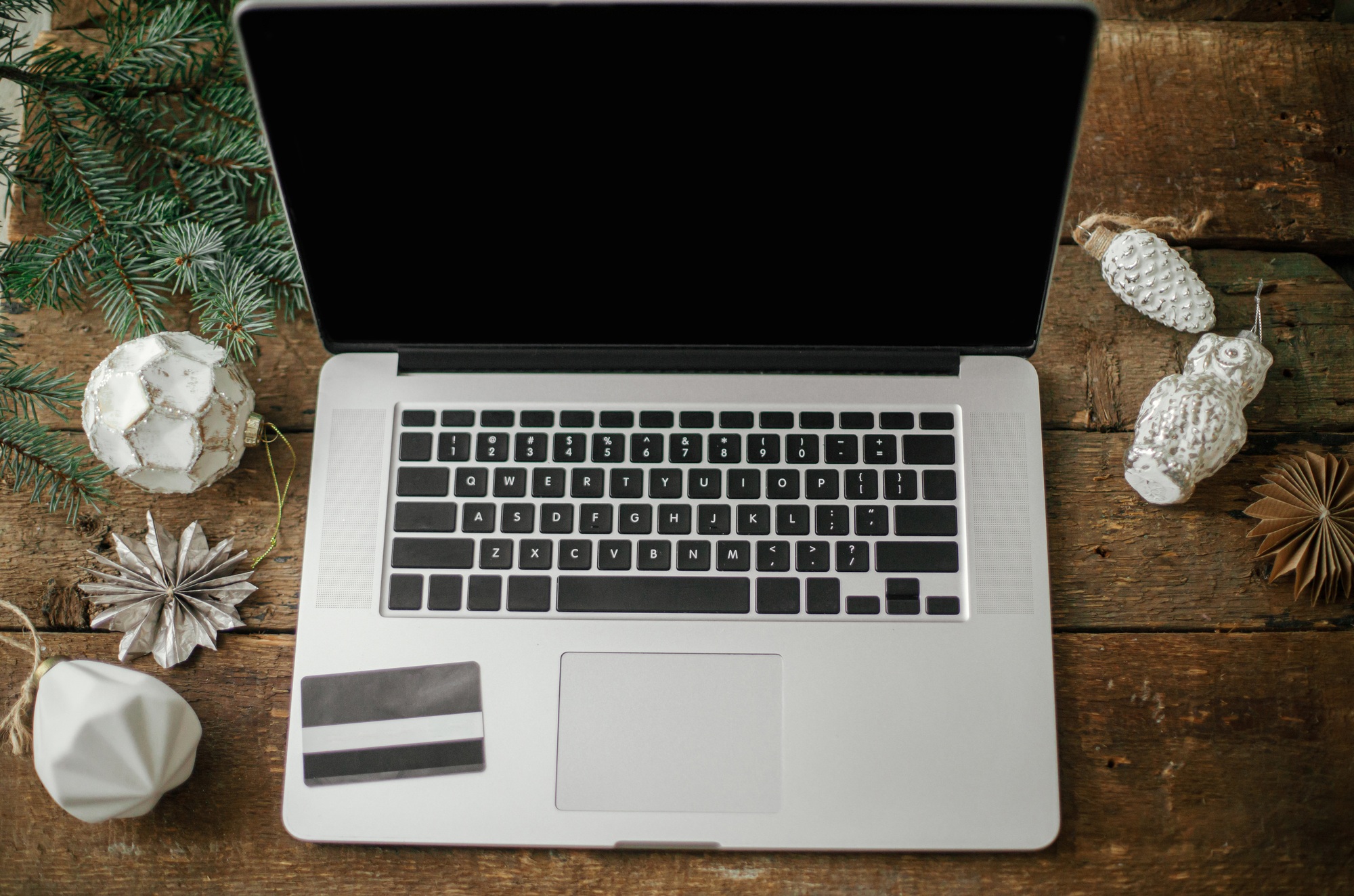 Christmas Sales and shopping online. Credit card on laptop on rustic table with christmas decor