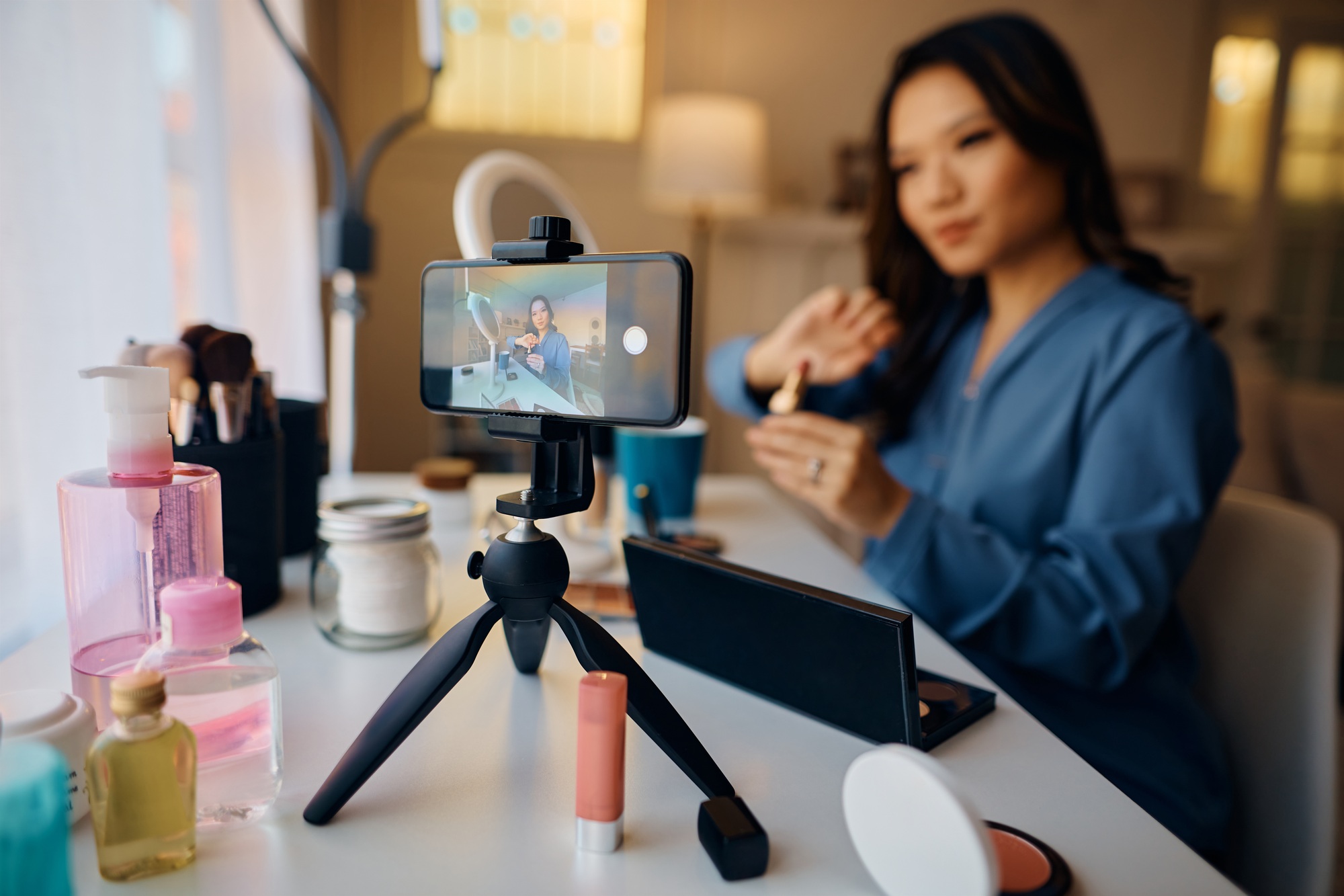 Close up of beauty vlogger recording makeup tutorial for her social media channel.