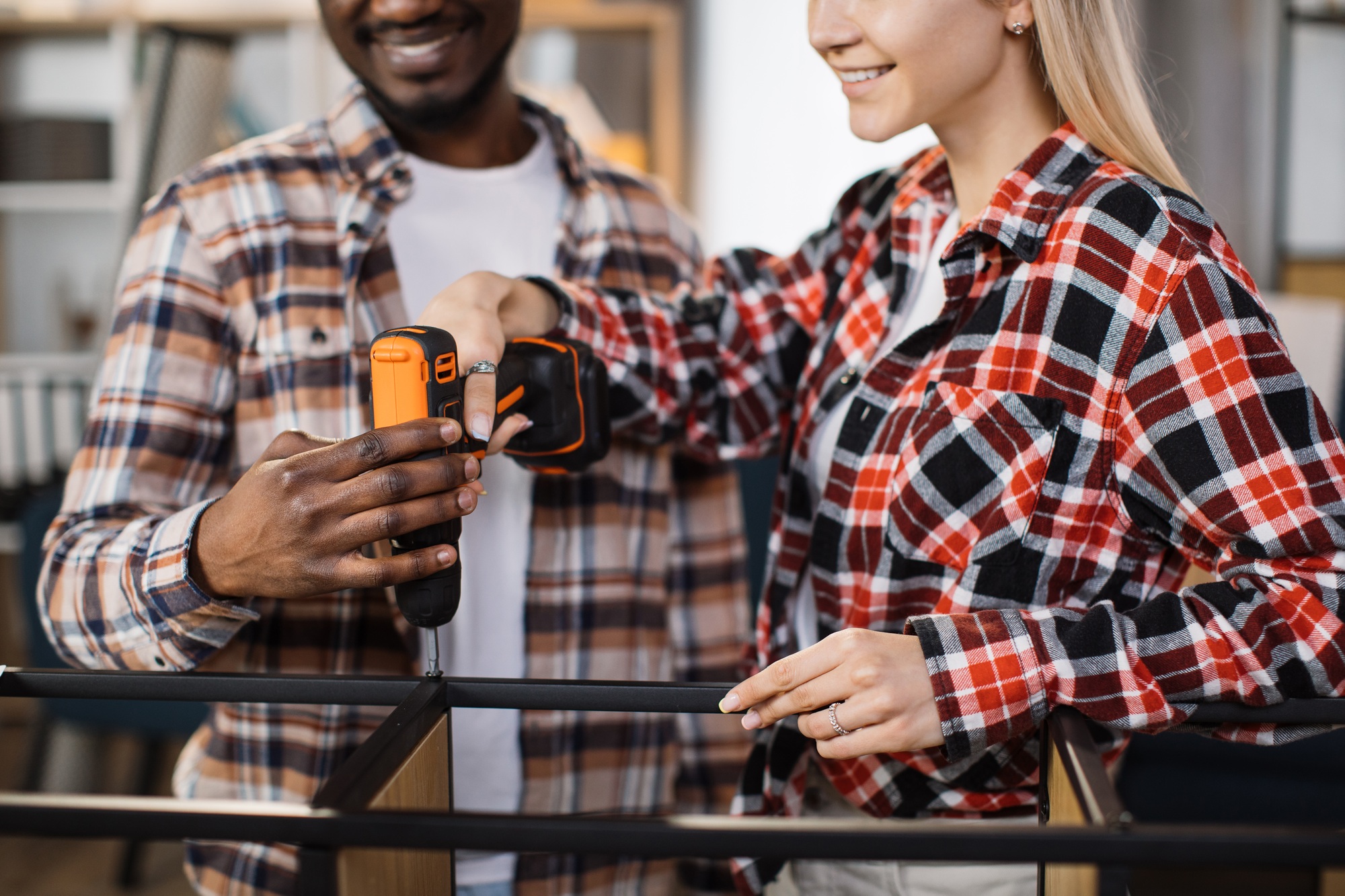 Close up of couple using screwdriver for assembling bookcase