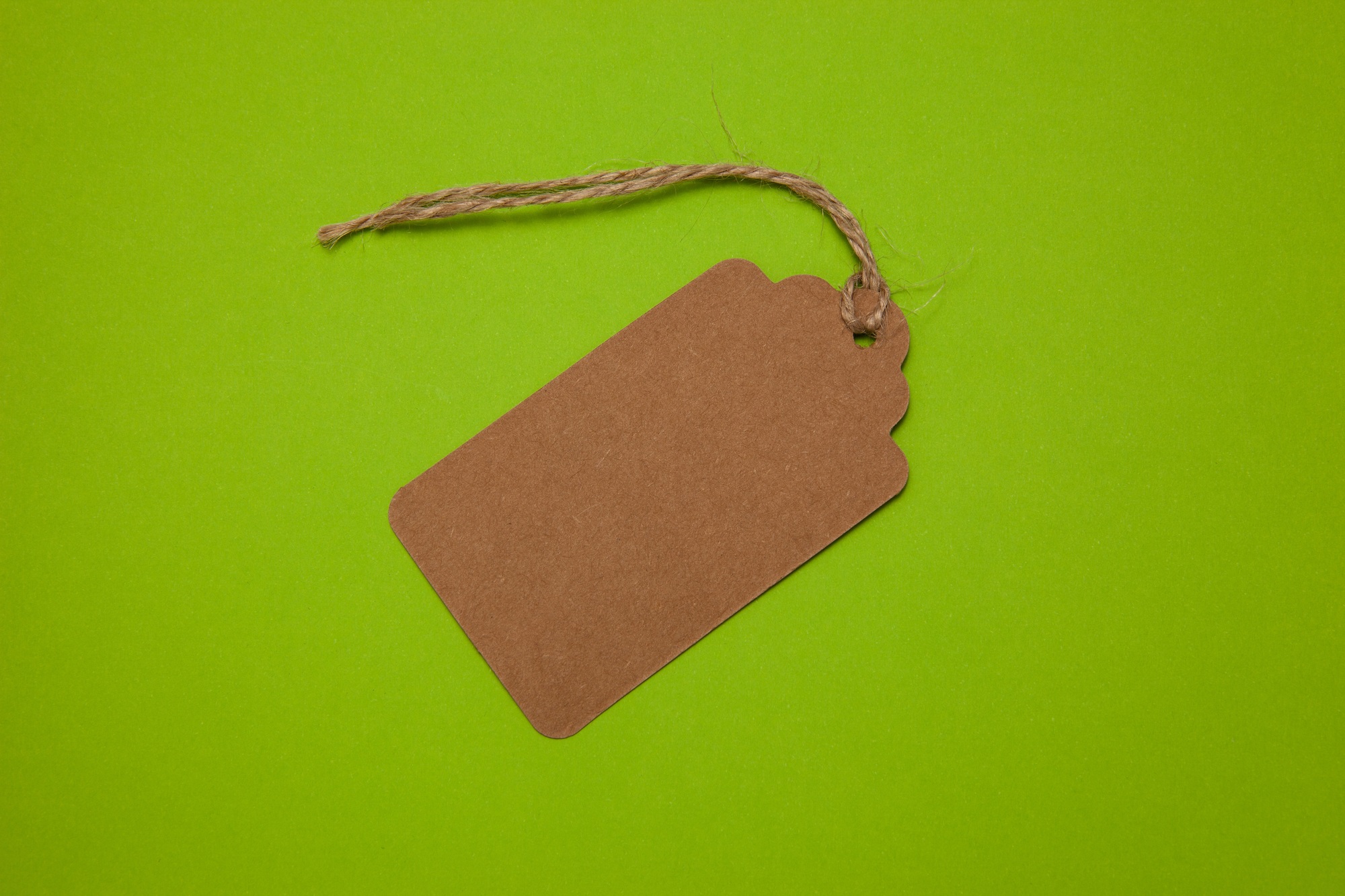 Close-up, price tag on a green background, top view. Sales concept