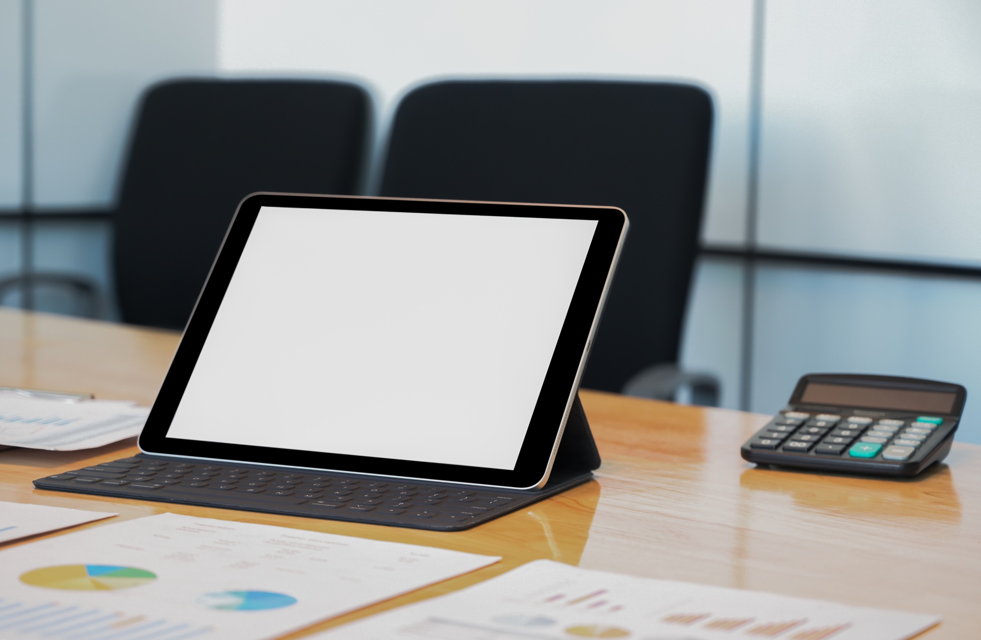 Close - up shot of Mockup modern tablet with data chart on the desk.